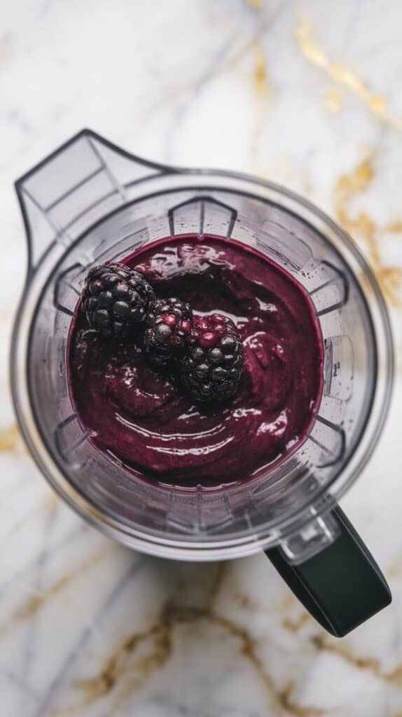 mulberries, fresh lemon juice, and honey blending into a deep purple smooth purée inside a clear blender cup, texture glossy and thick