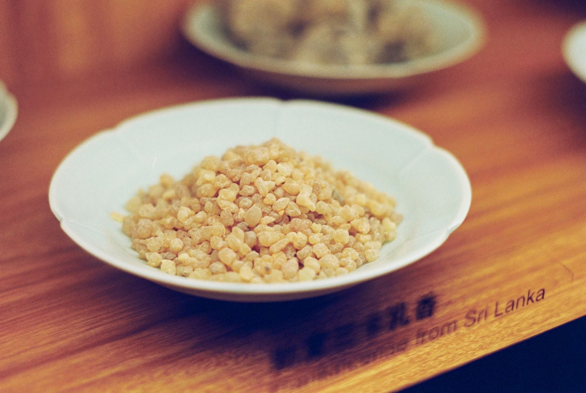 Golden translucent frankincense resin pieces piled on a dark stone surface