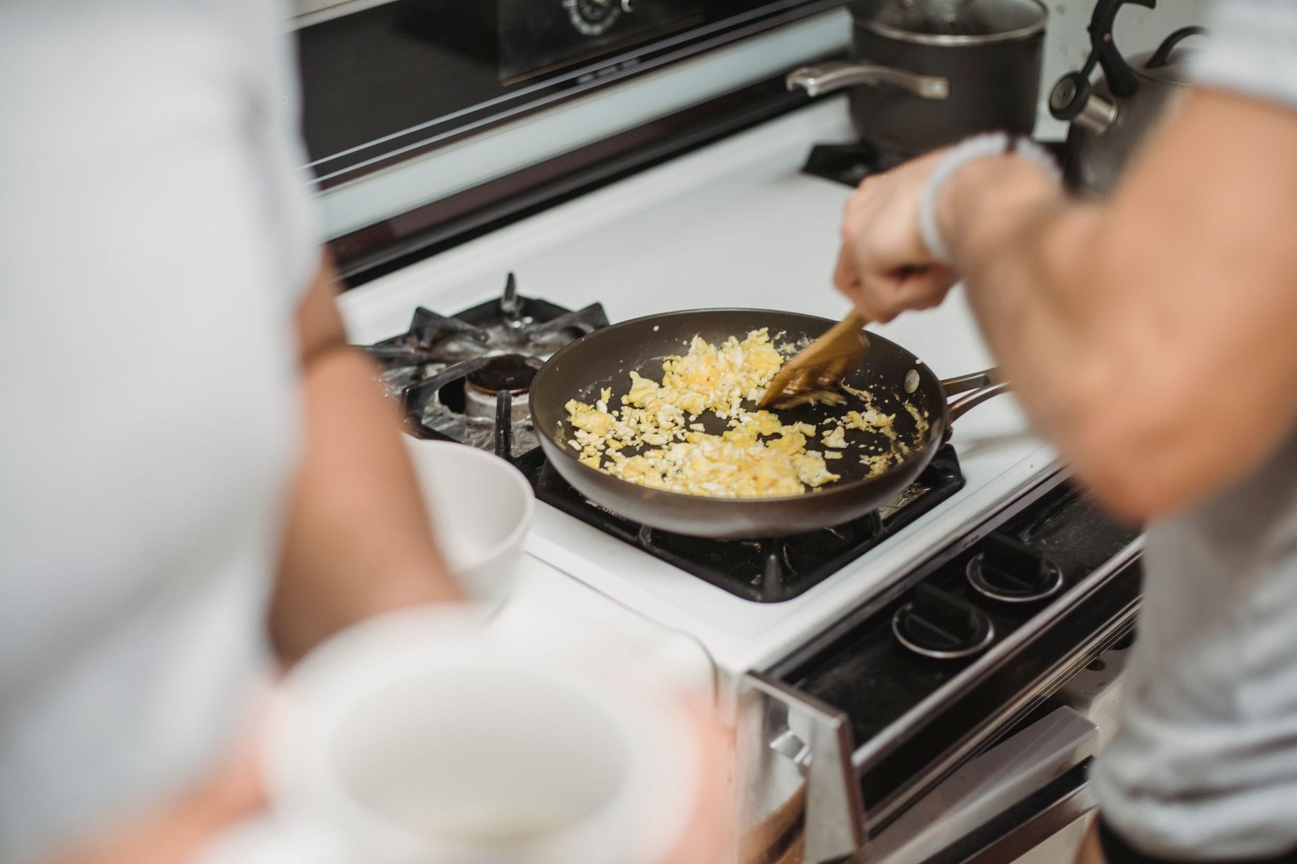 Fluffy scrambled eggs cooking in a stainless steel skillet