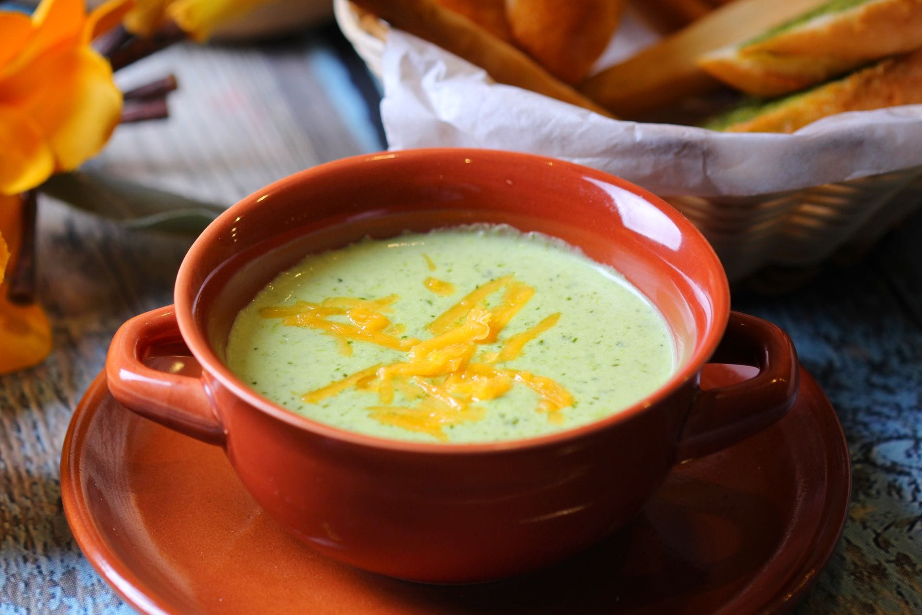 Bowl of creamy green broccoli soup garnished with parsley and cracked pepper