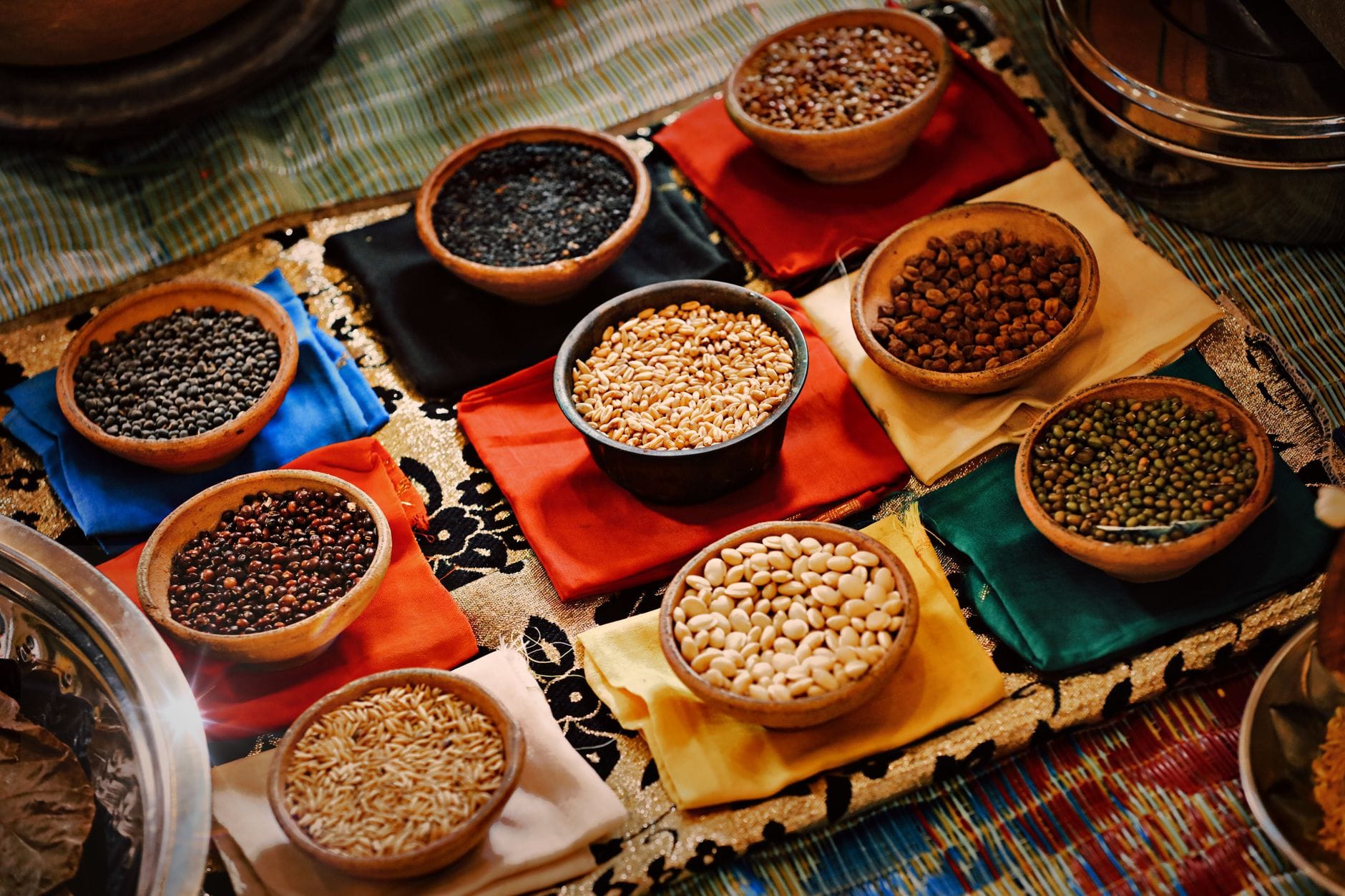 Assorted dried lentils and beans in small bowls on a wooden surface