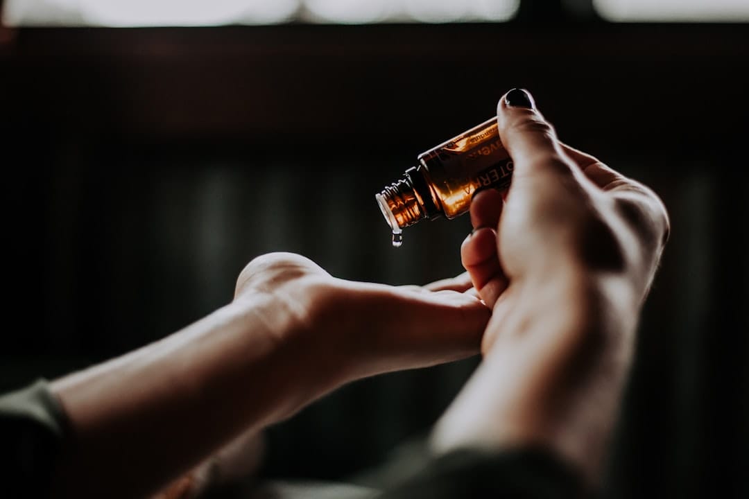 Woman running oil through the ends of her long dark hair with her fingers