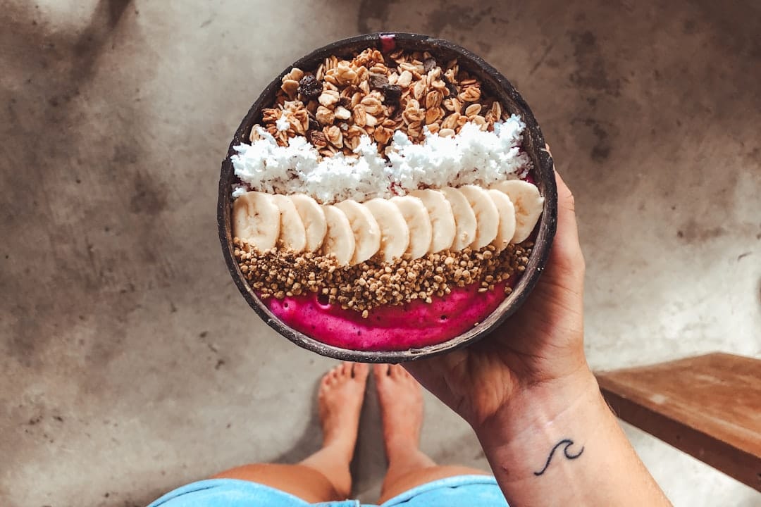 Breakfast bowl topped with coconut flakes, banana slices and berries