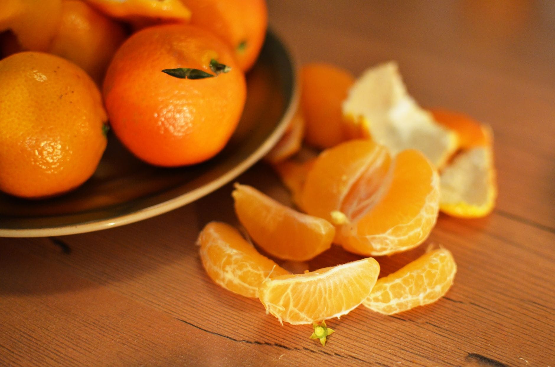 Bright peeled tangerine split into segments beside its curled orange skin
