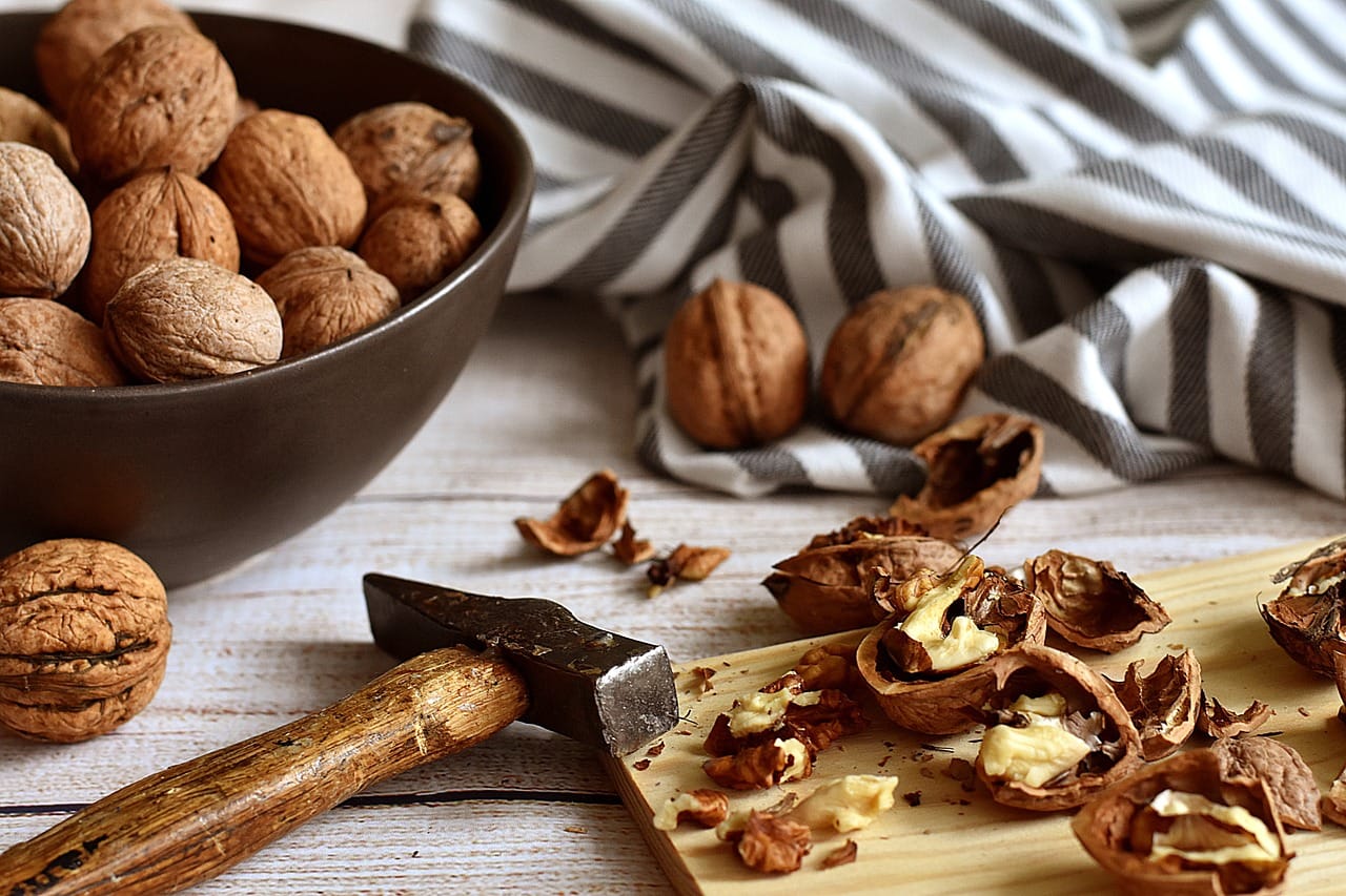 Fresh walnut halves piled high in a rustic wooden bowl