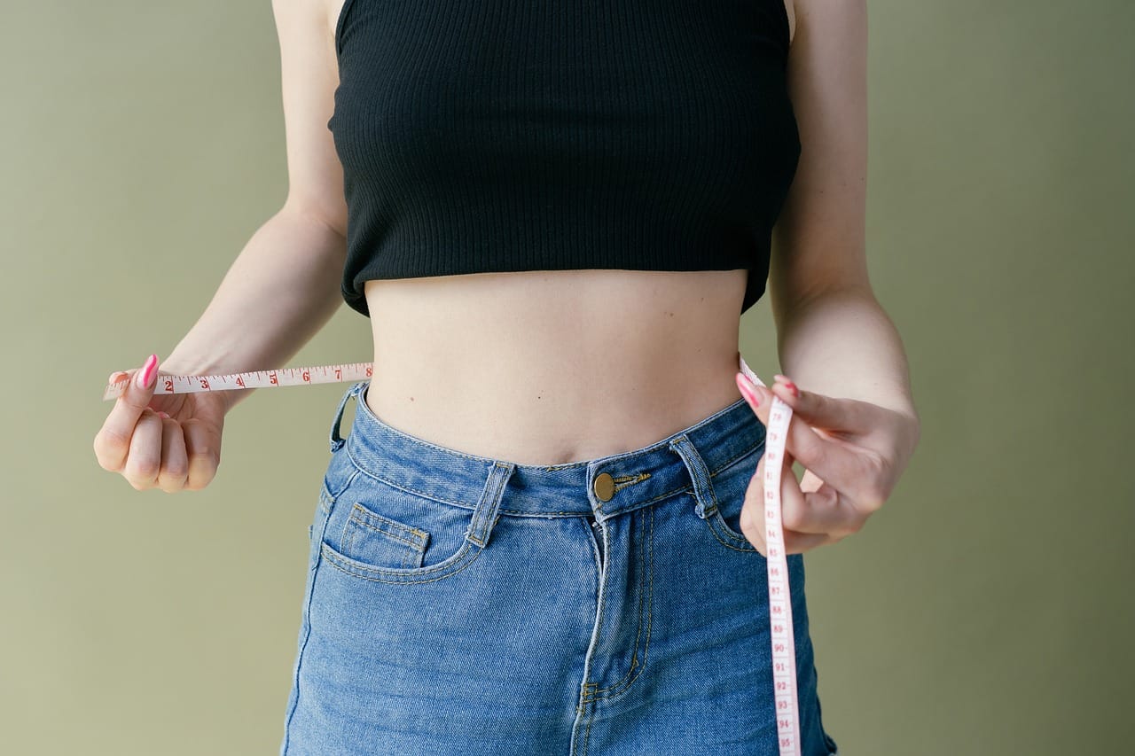 A tape measure wrapped snugly around a person's midsection