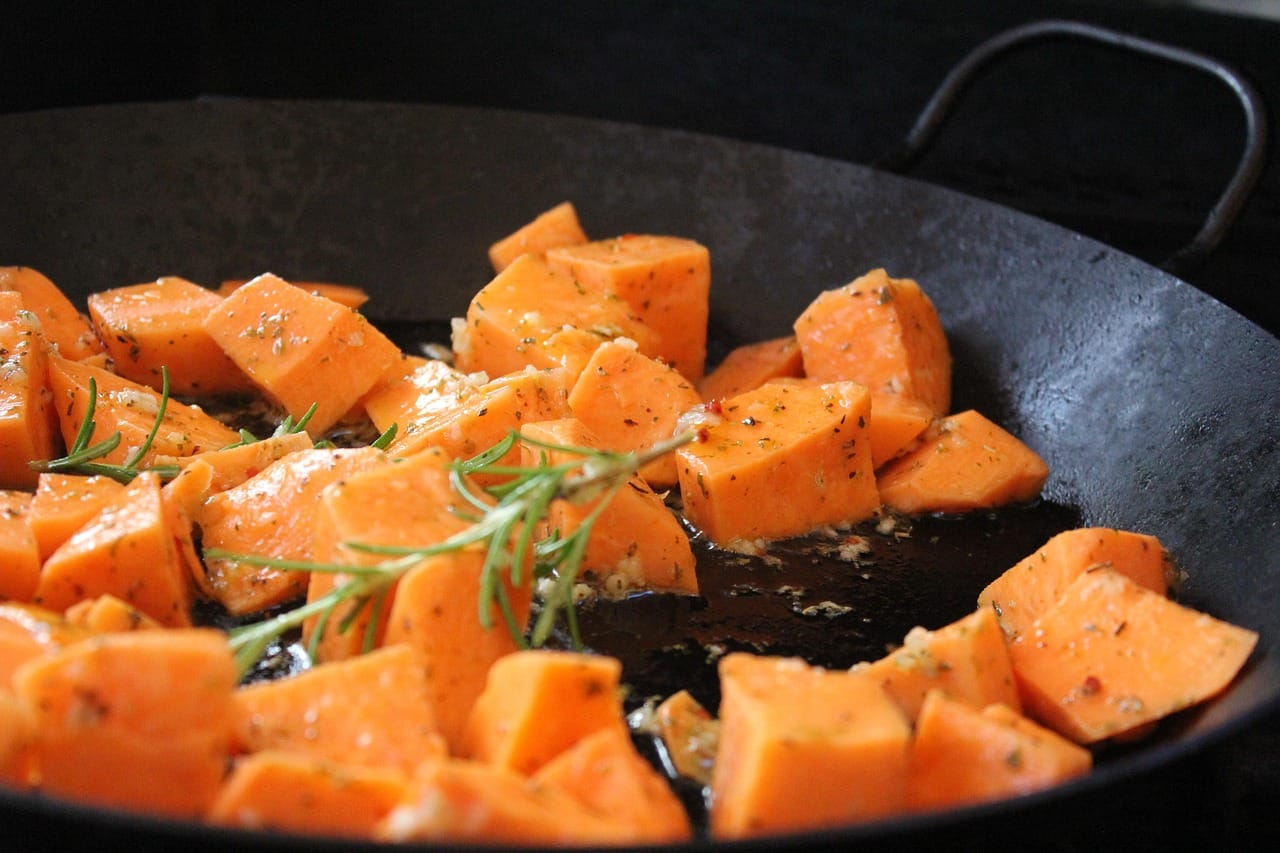 Halved roasted sweet potato with pumpkin seeds on a plate
