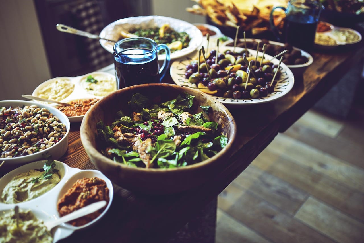Fresh green olives resting in a rustic wooden bowl on wood