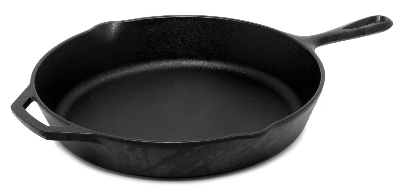 Seasoned meat and vegetables searing in a hot cast iron pan