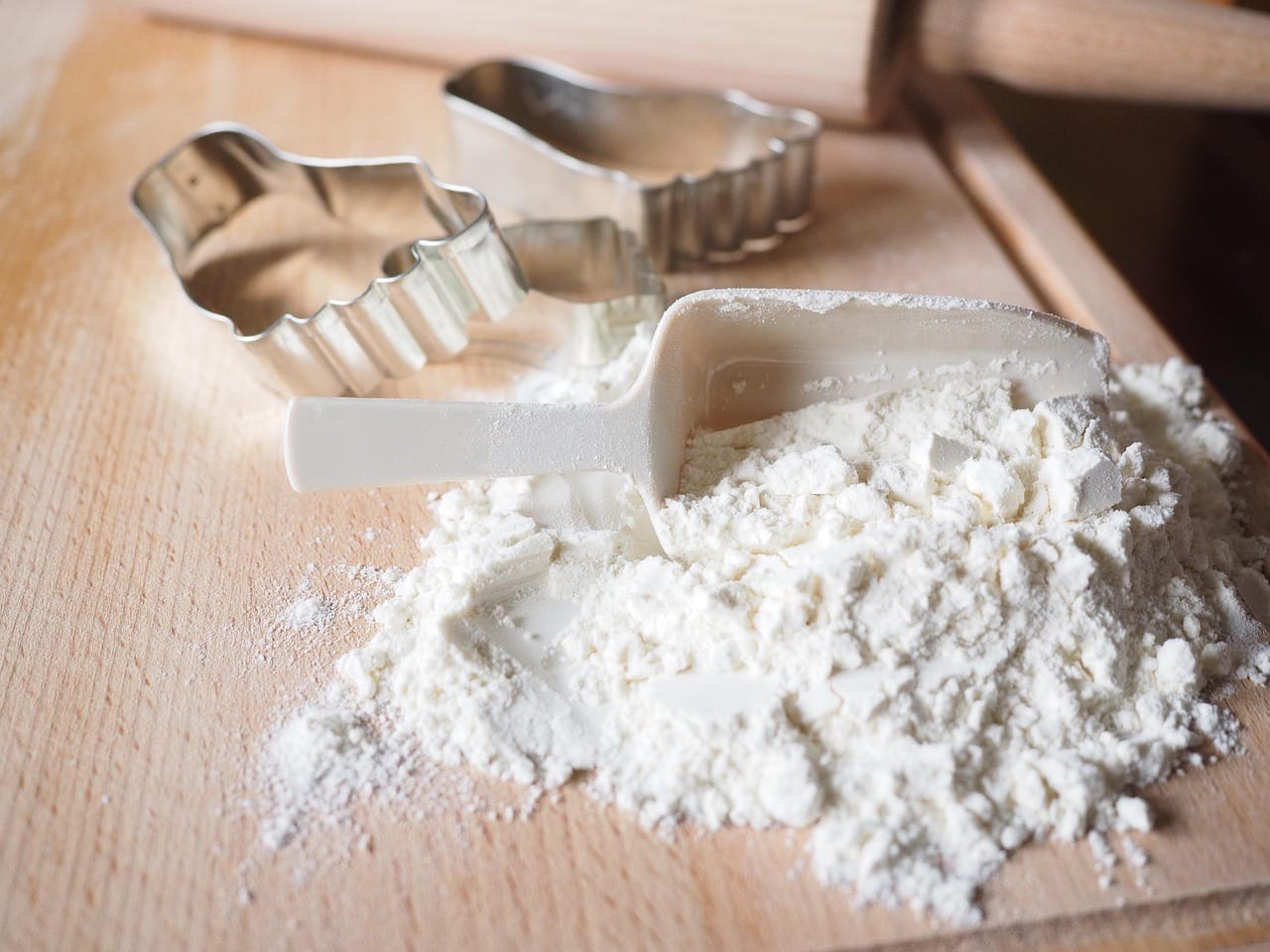 Wooden scoop of pale coconut flour on a countertop