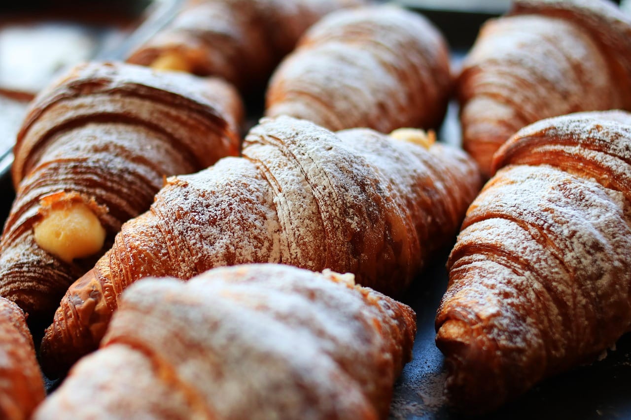 Golden flaky croissants cooling on a wire rack