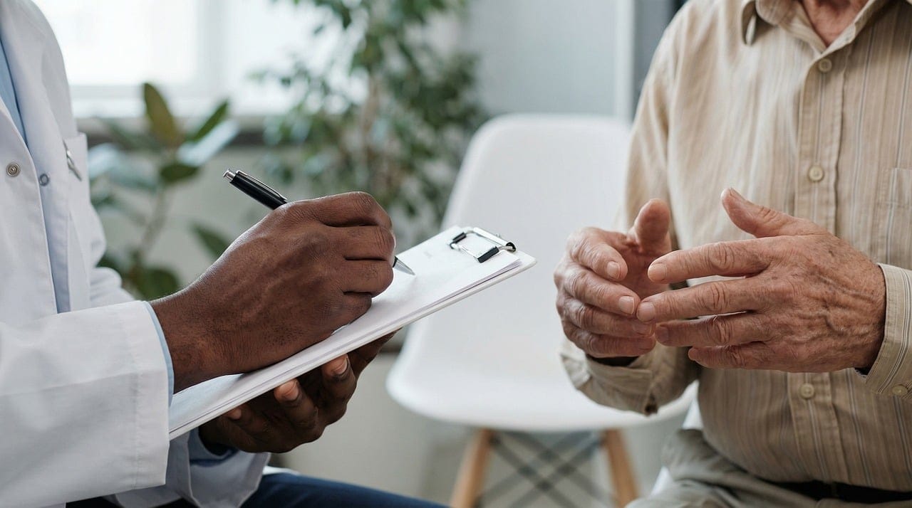 A physician in a white coat gently examining a patient's fingers
