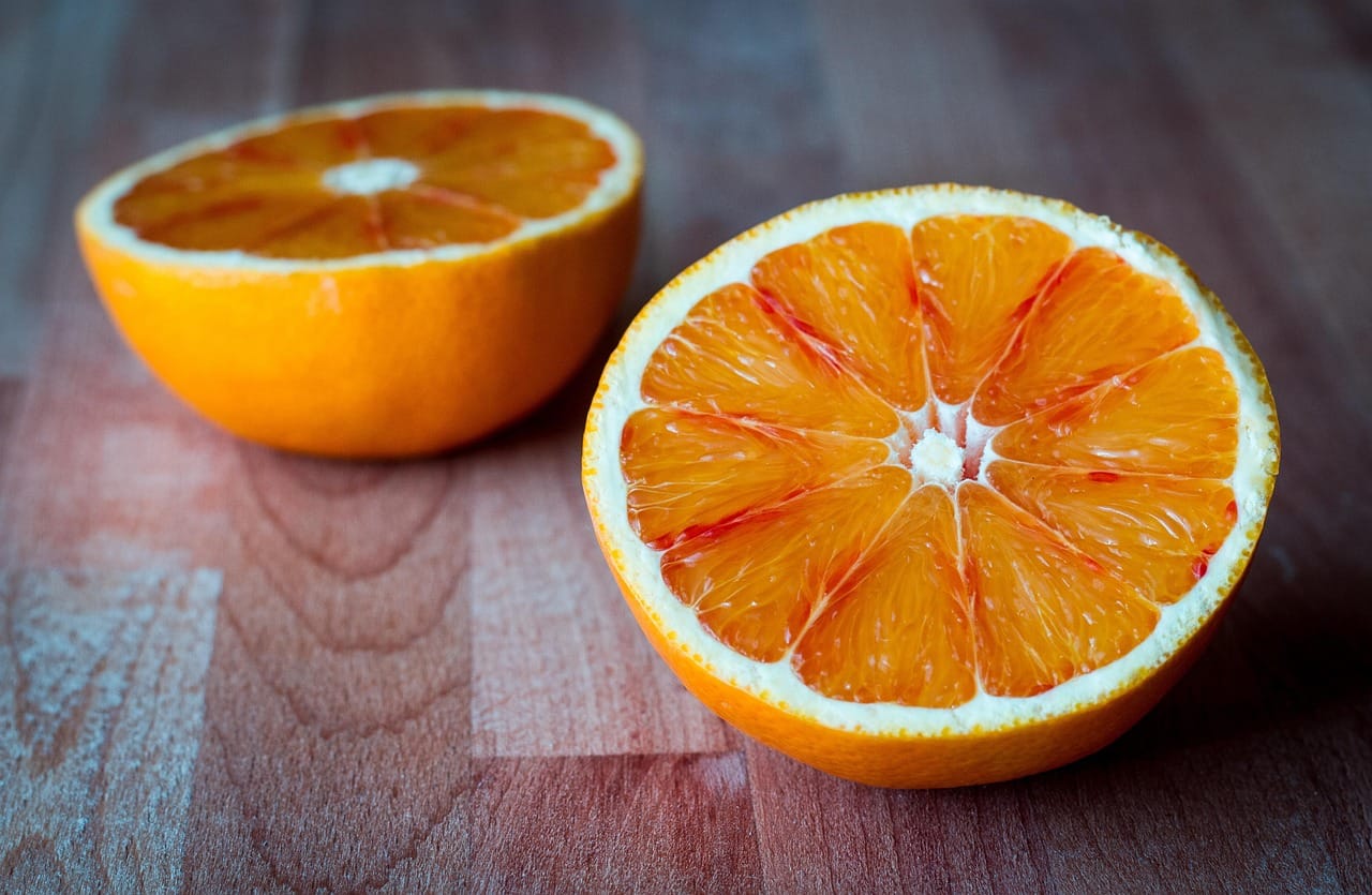 Assorted halved oranges and lemons arranged on a wooden board