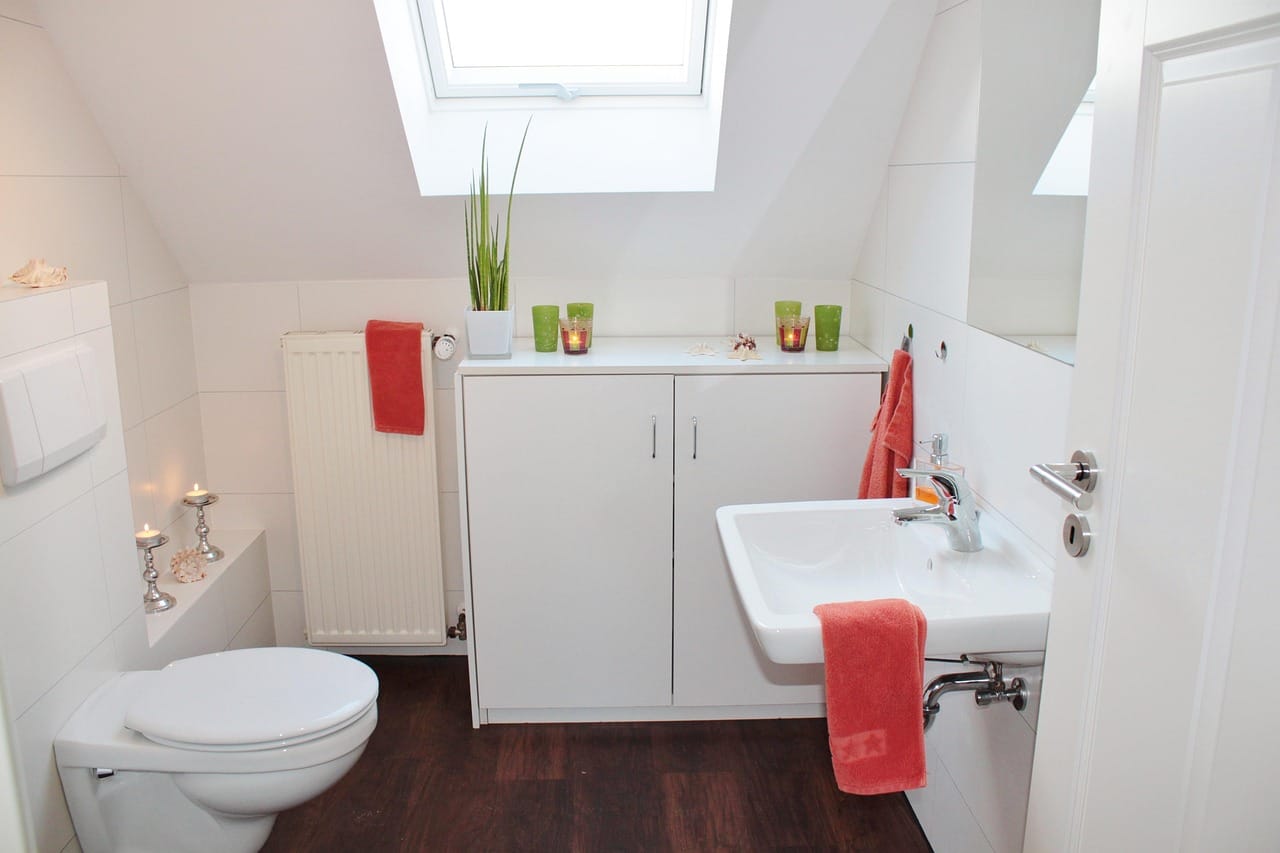 A clean white toilet beside tiled walls in a sunlit bathroom