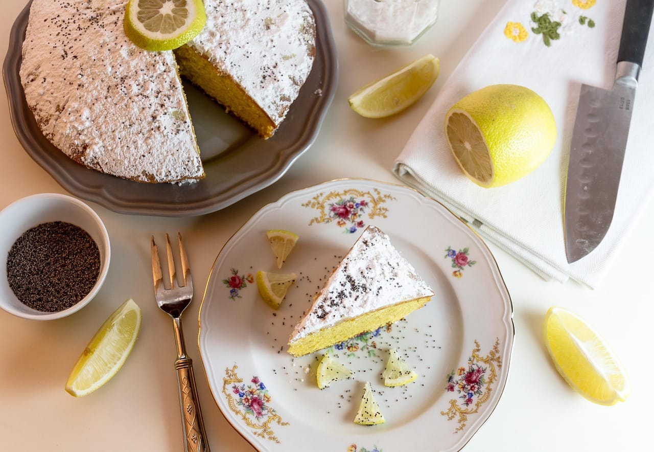 Squares of lemon bars dusted with powdered sugar on parchment