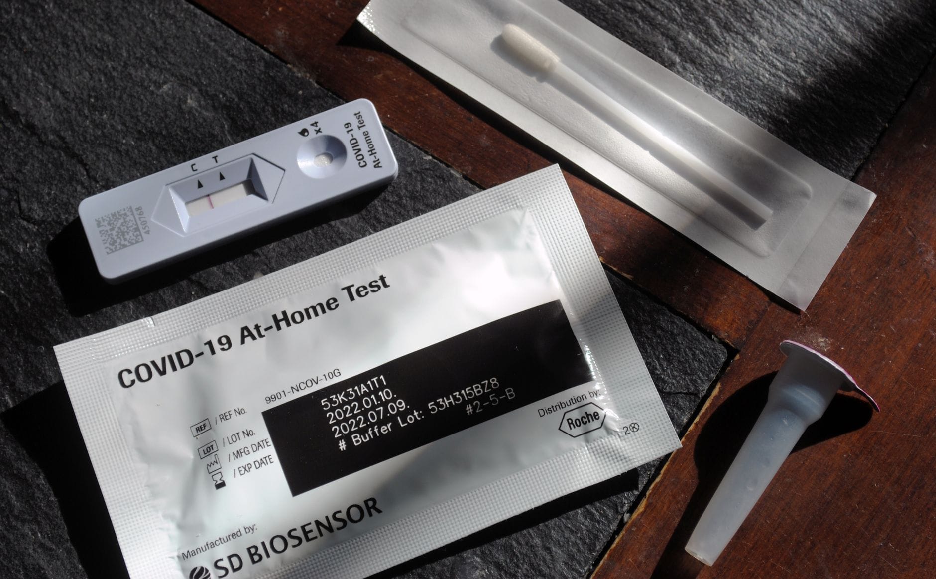 Chemical test strips laid beside a color comparison chart on a white surface
