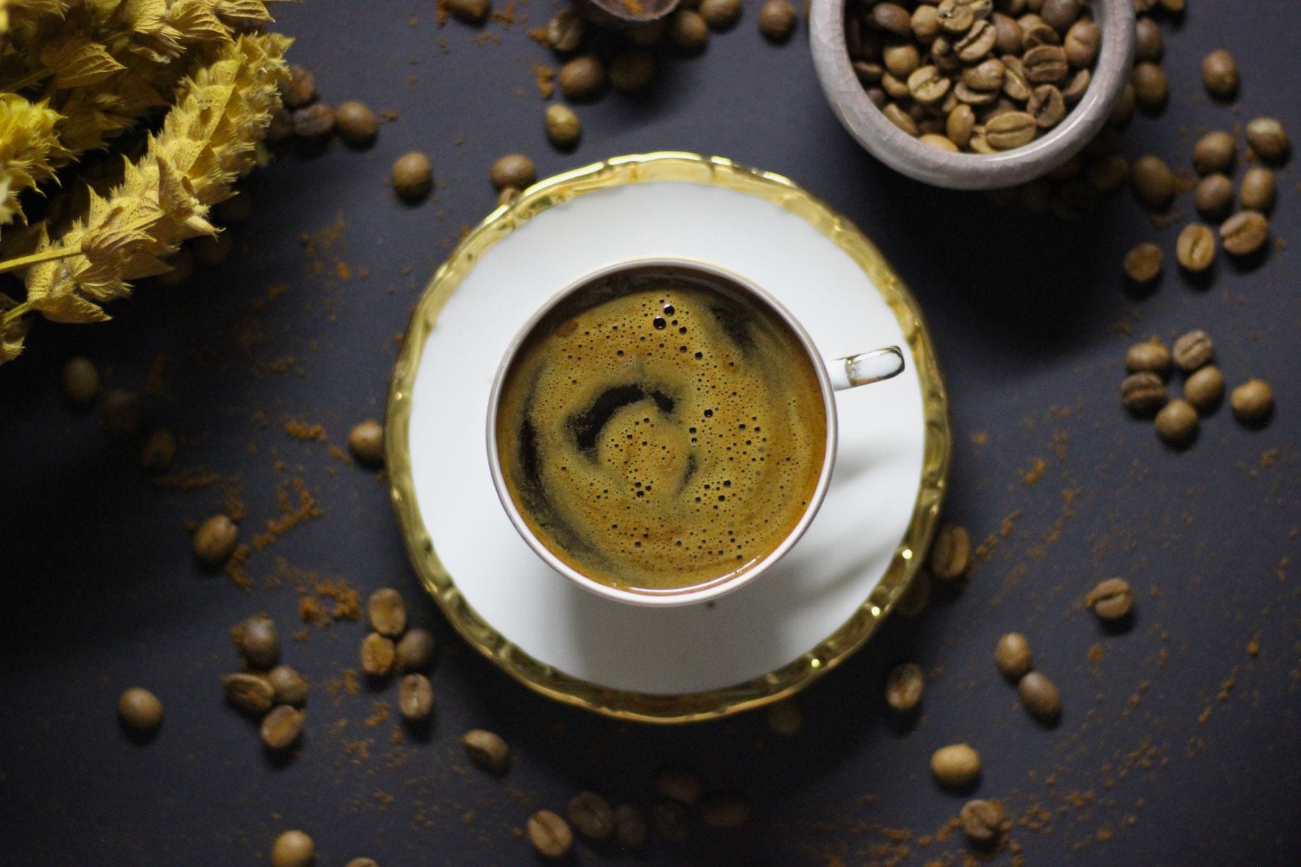 Steaming black coffee in a plain white ceramic cup on a wooden table