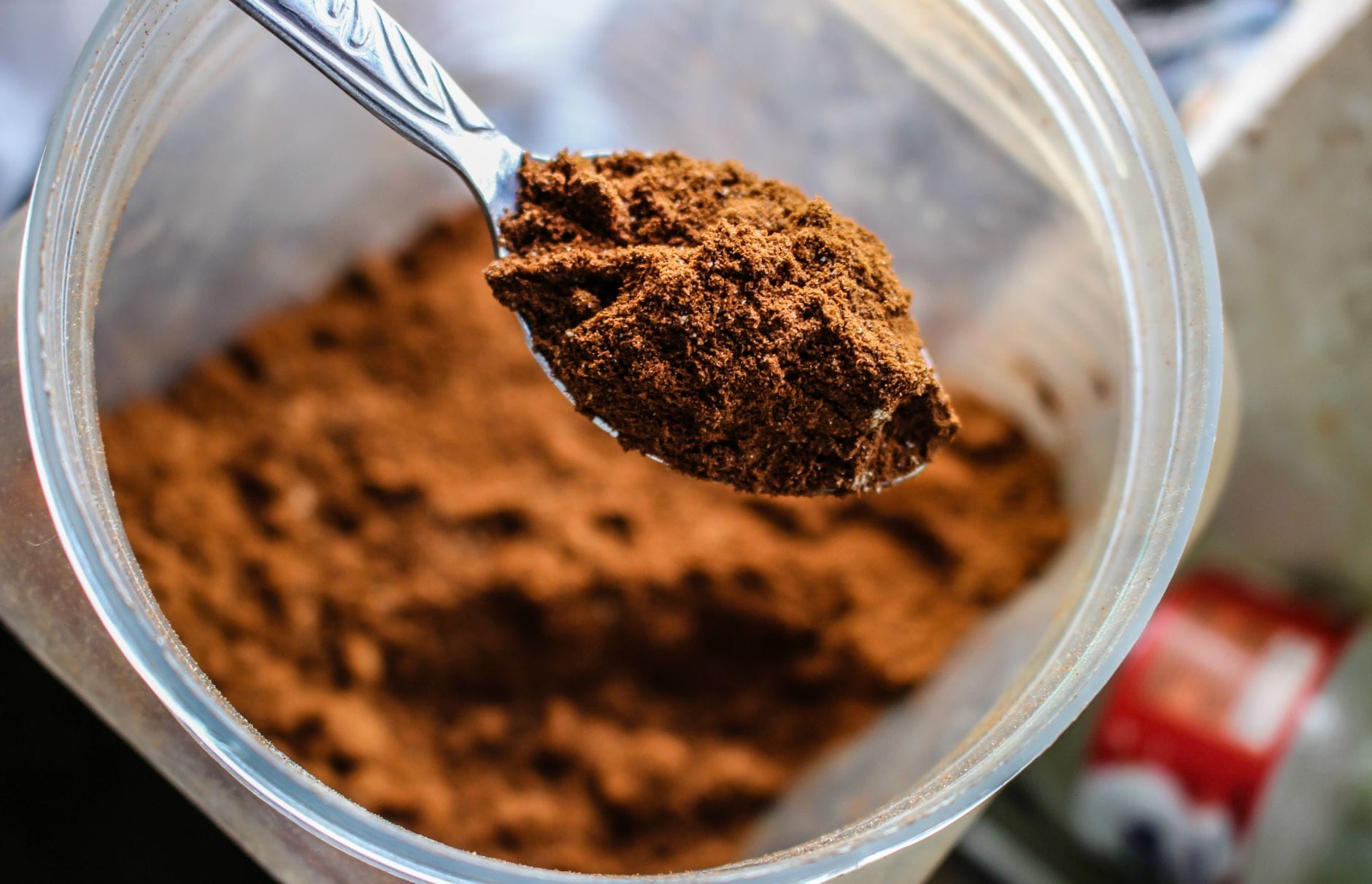 Red-orange ground spice heaped on a metal spoon over a bowl