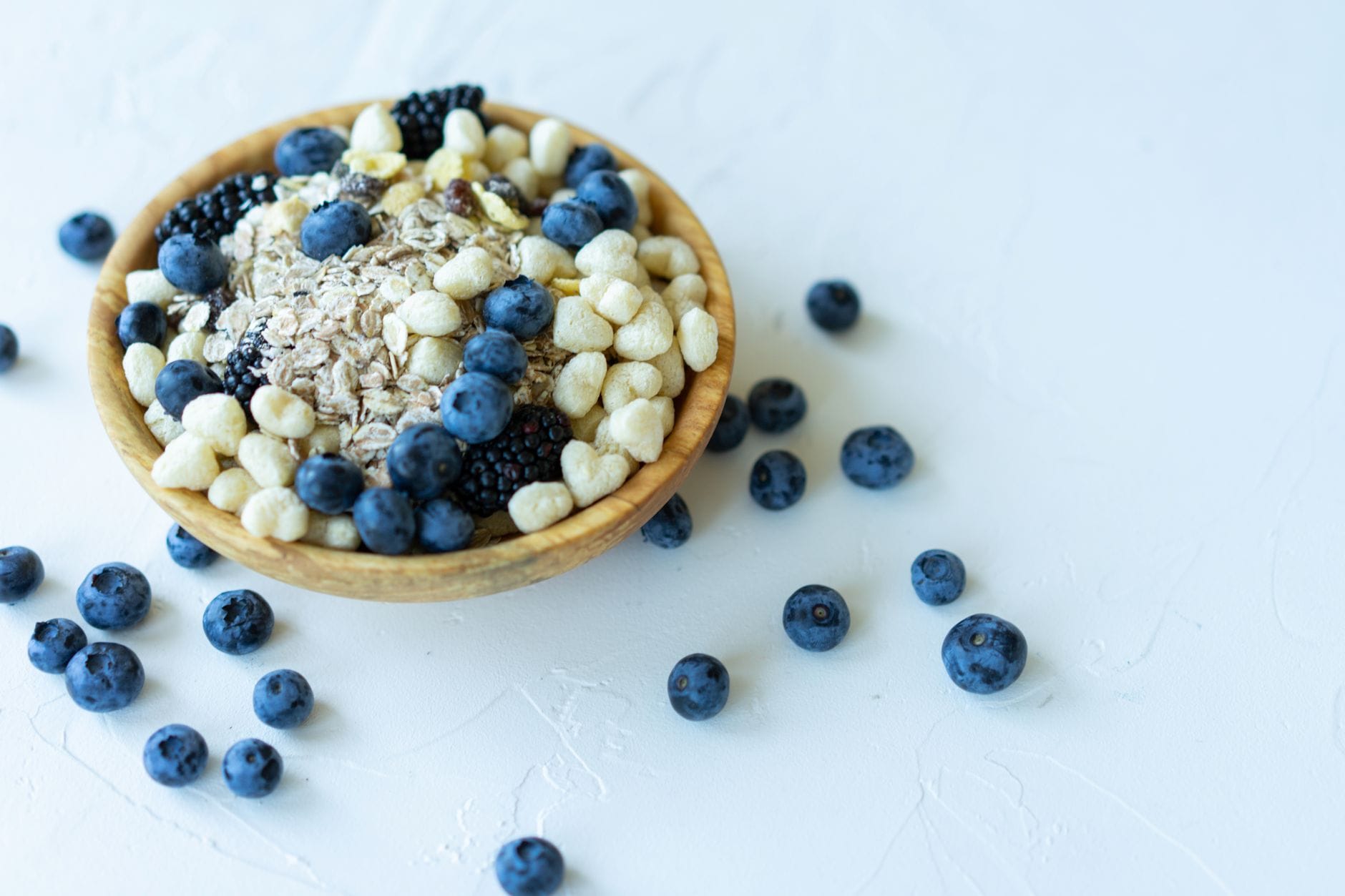 Wooden bowl filled with mixed fresh fruit on a kitchen counter