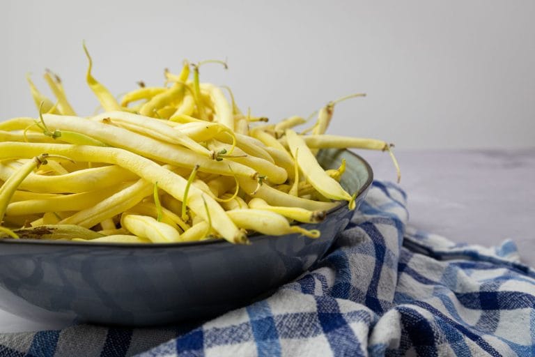 Creamy white cannellini beans piled in a rustic ceramic bowl on a wooden table