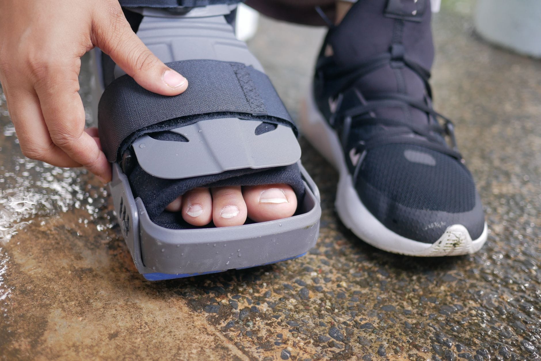 A blue gel ice pack pressed against a bare ankle resting on a towel