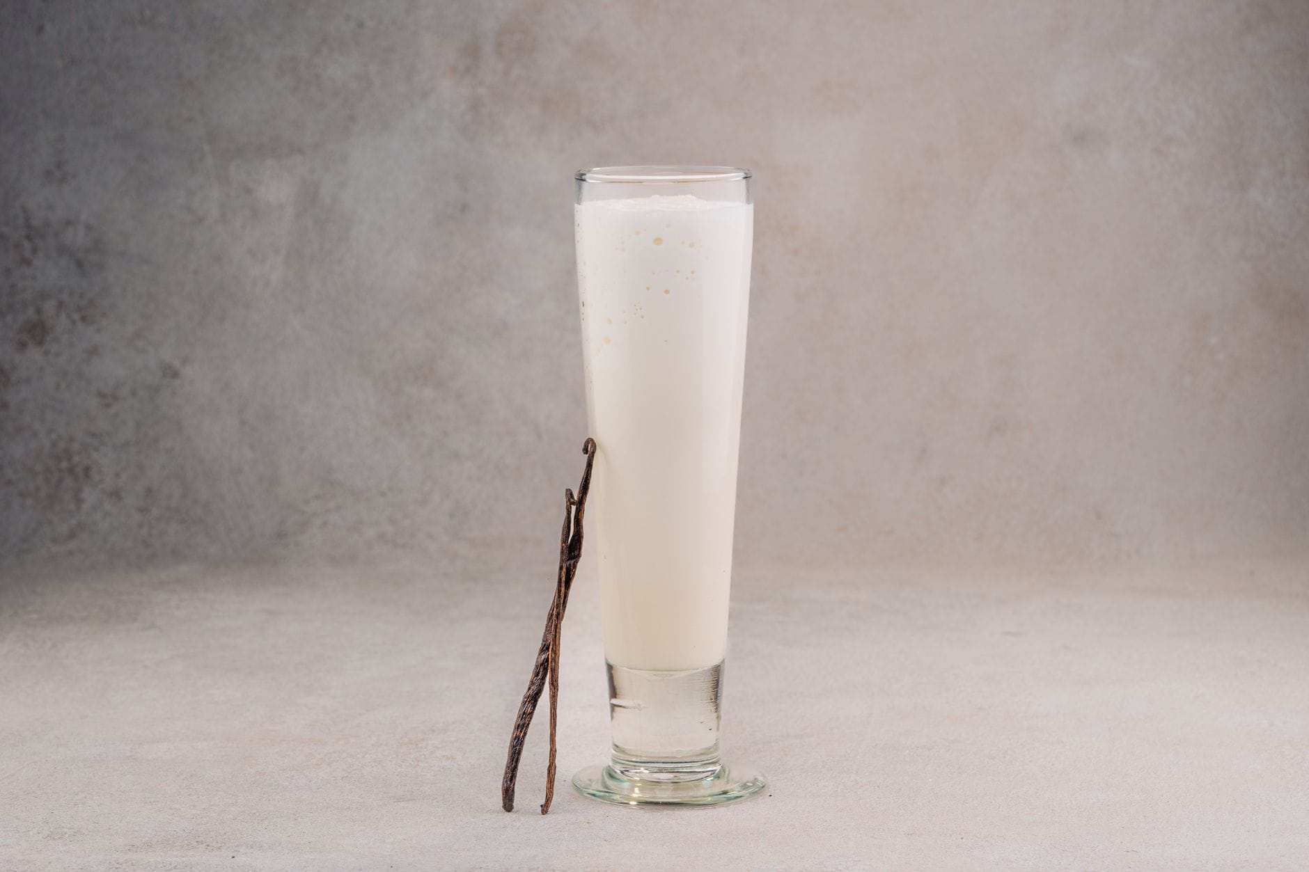 A full glass of milk standing on a wooden kitchen table