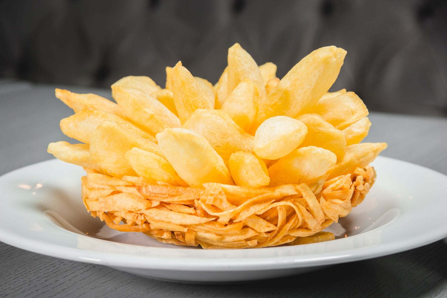 crispy french fries draining in a metal fryer basket