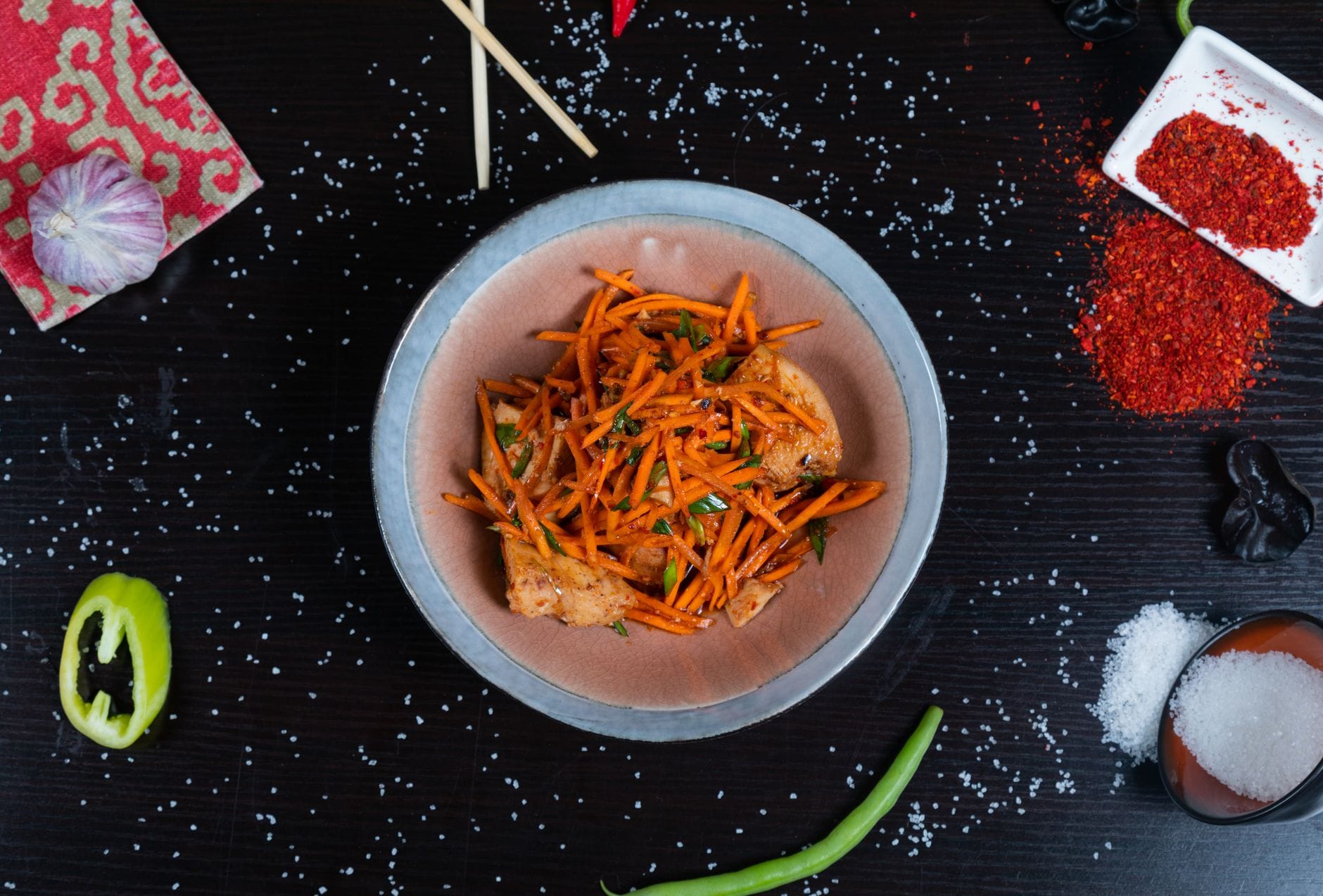 Stir-fried lotus root slices with peppers and scallions in a dark pan
