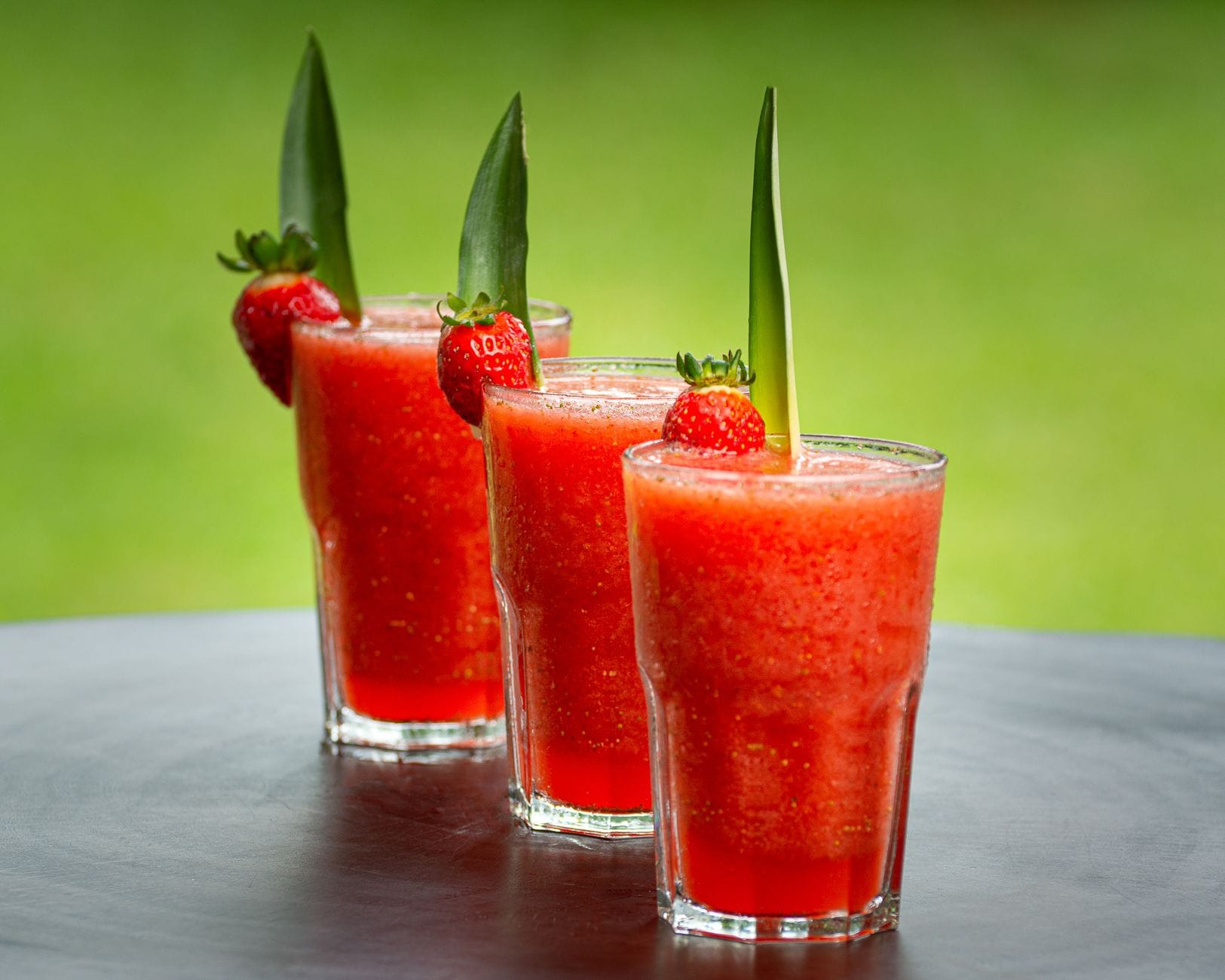 Creamy pale-orange smoothie in a tall glass topped with a straw