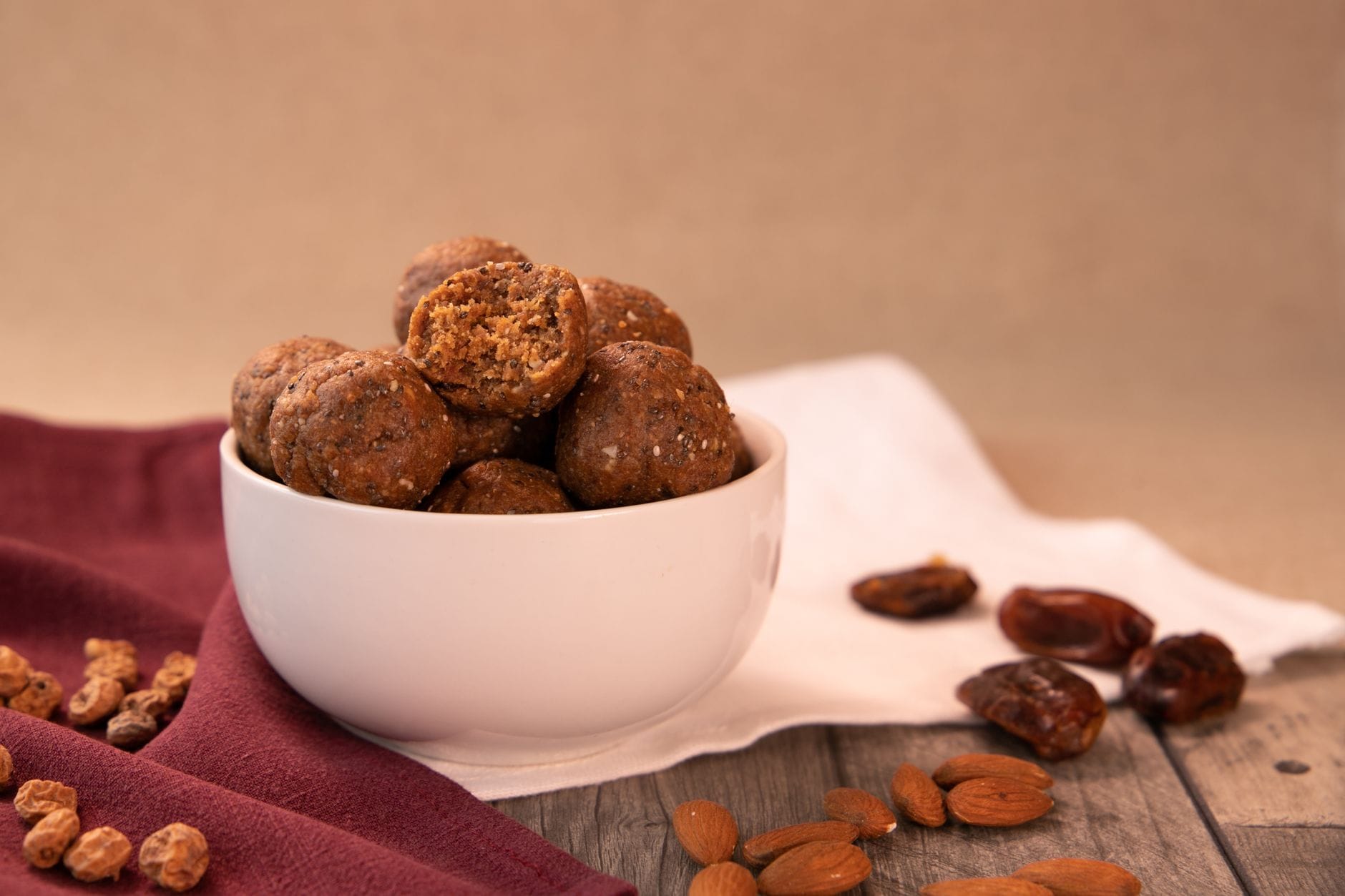 Rolled no-bake energy balls made with dates and nuts on parchment