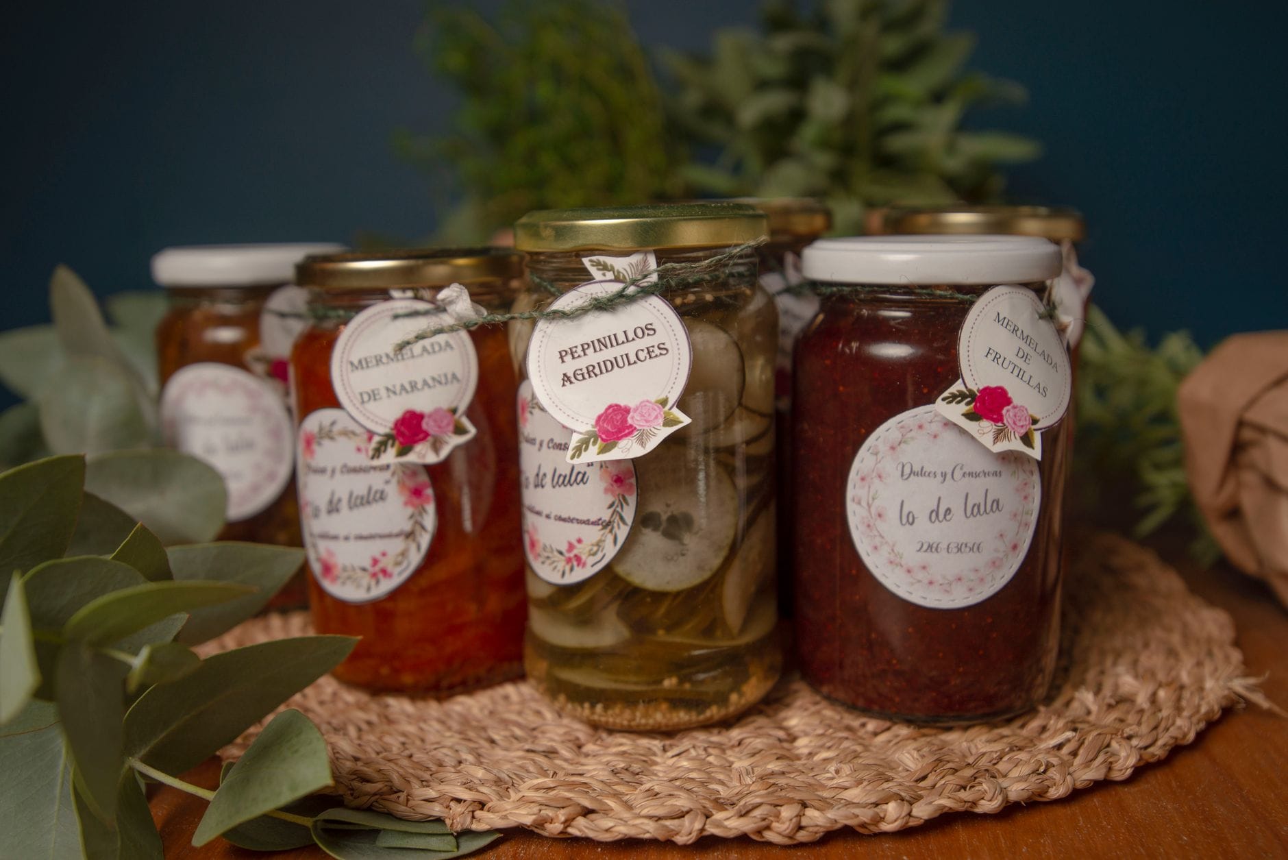 Rose-colored quince preserve in a glass jar beside slices of fresh fruit