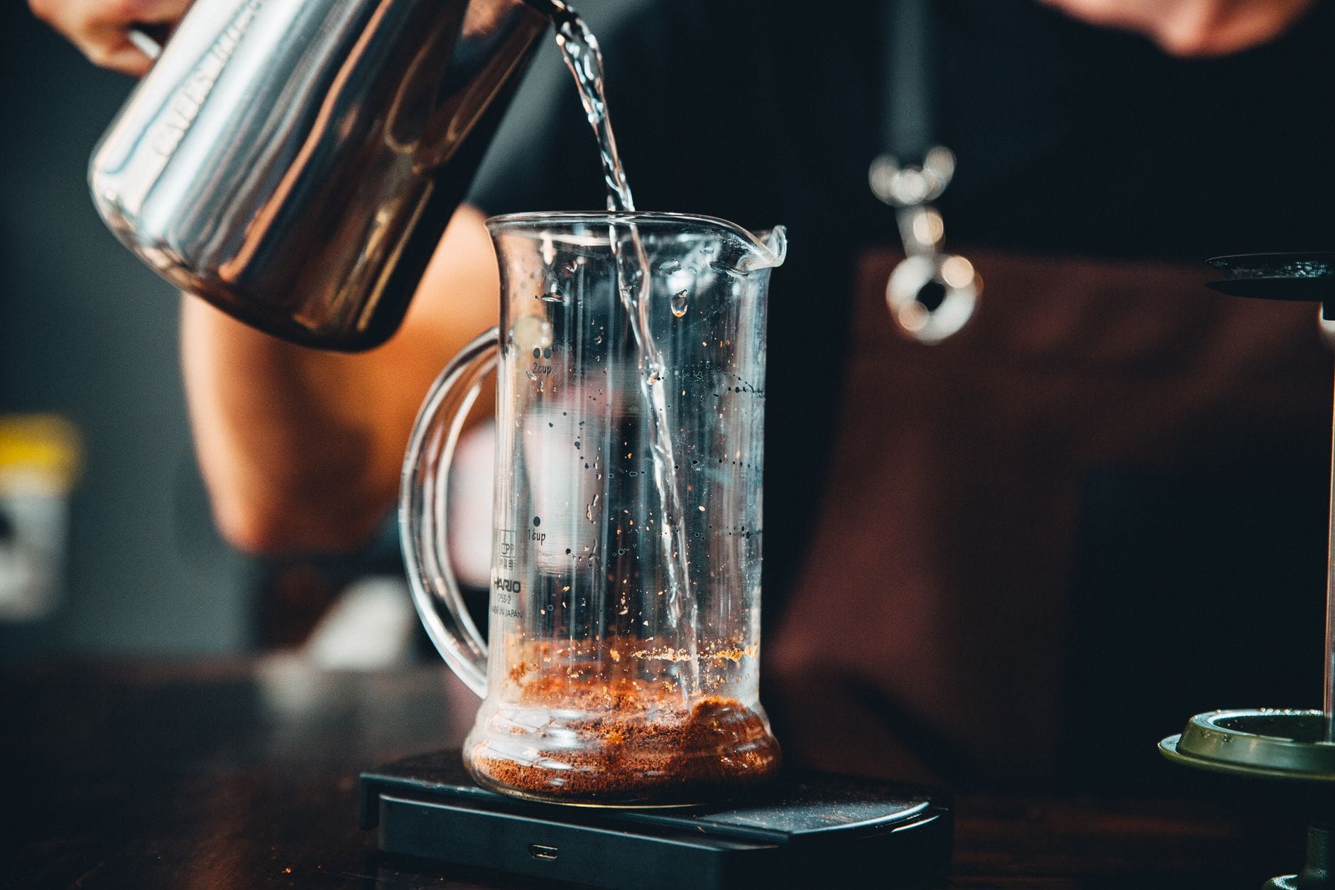 Clear glass measuring pitcher filled with pale juice on a kitchen counter