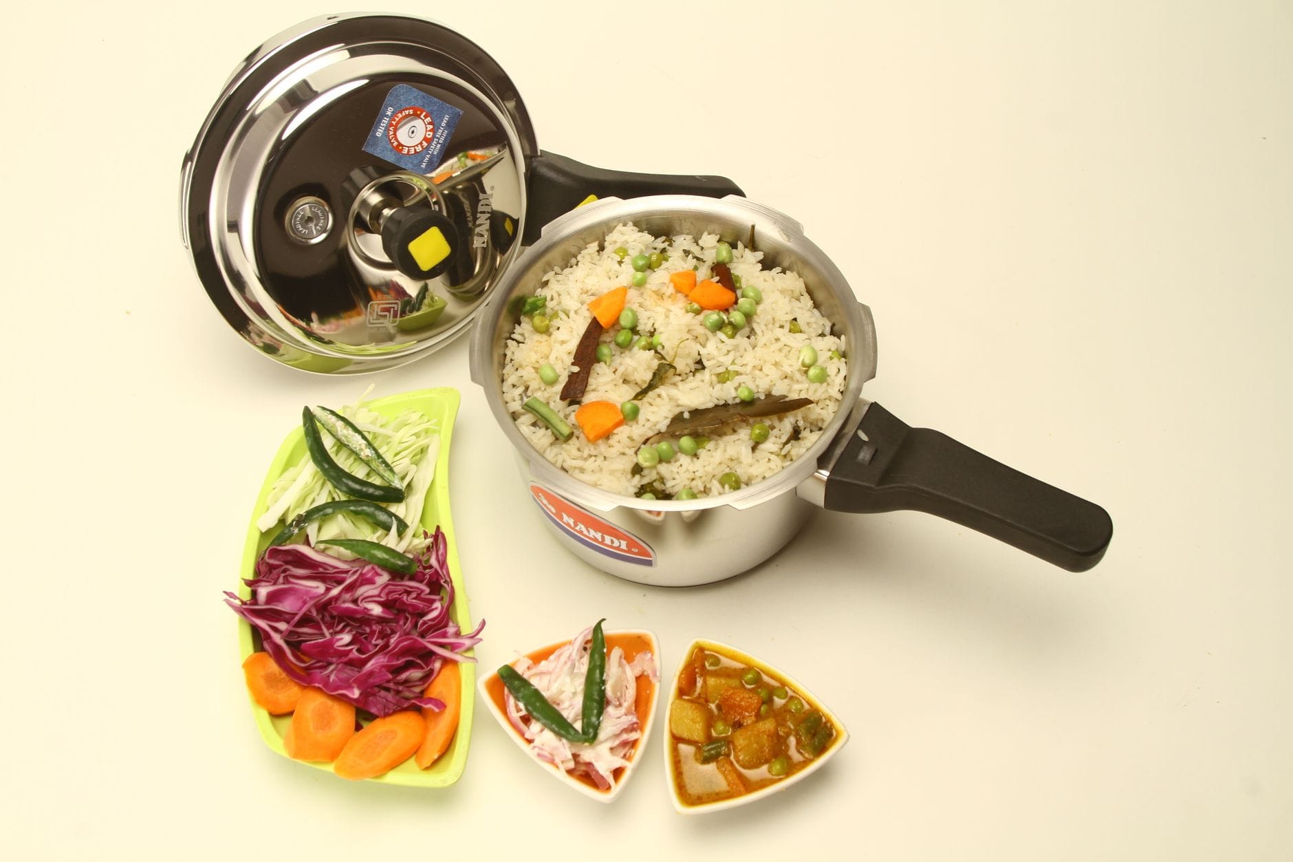 Stainless steel pressure cooker steaming on a kitchen stovetop
