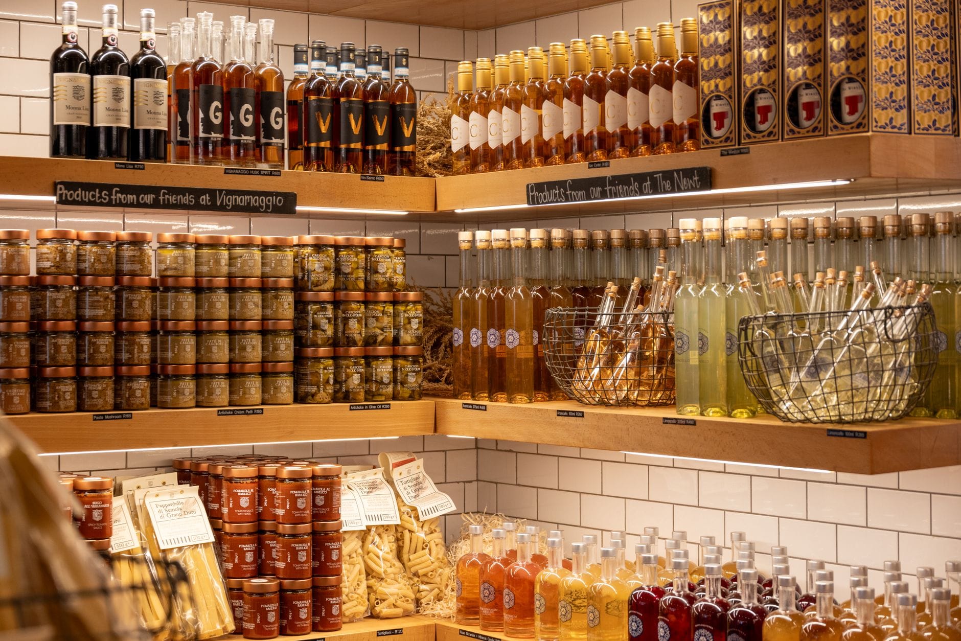 Several dark glass bottles of olive oil lined up on a wooden shelf