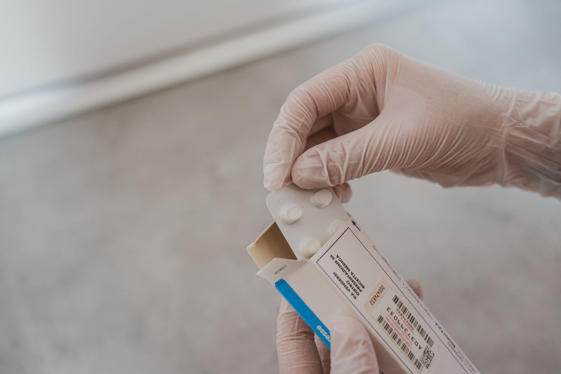 Hands wearing blue latex gloves against a plain background