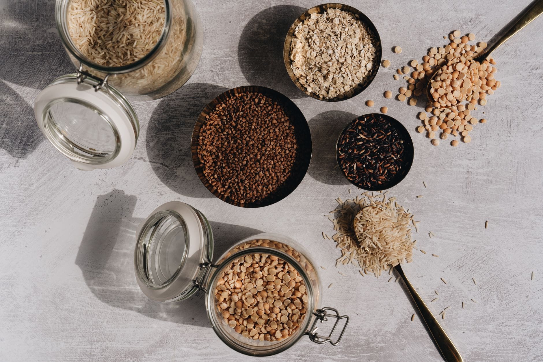 Glass jars filled with different whole grains on a shelf