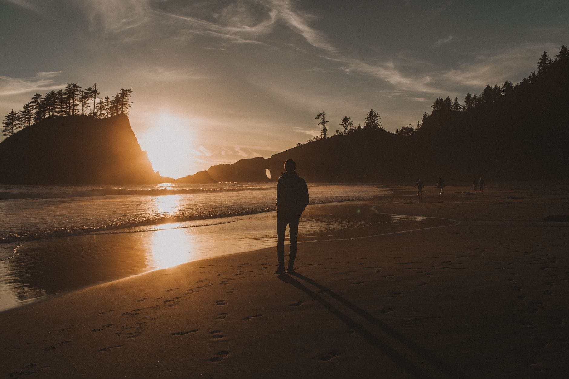 A person walking on a quiet path in early morning sunlight