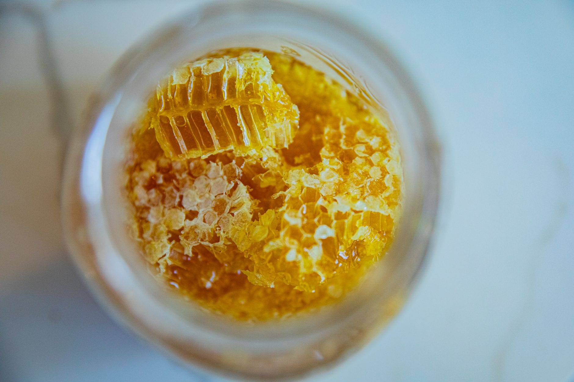 Person applying a glossy honey mixture to damp hair with fingertips