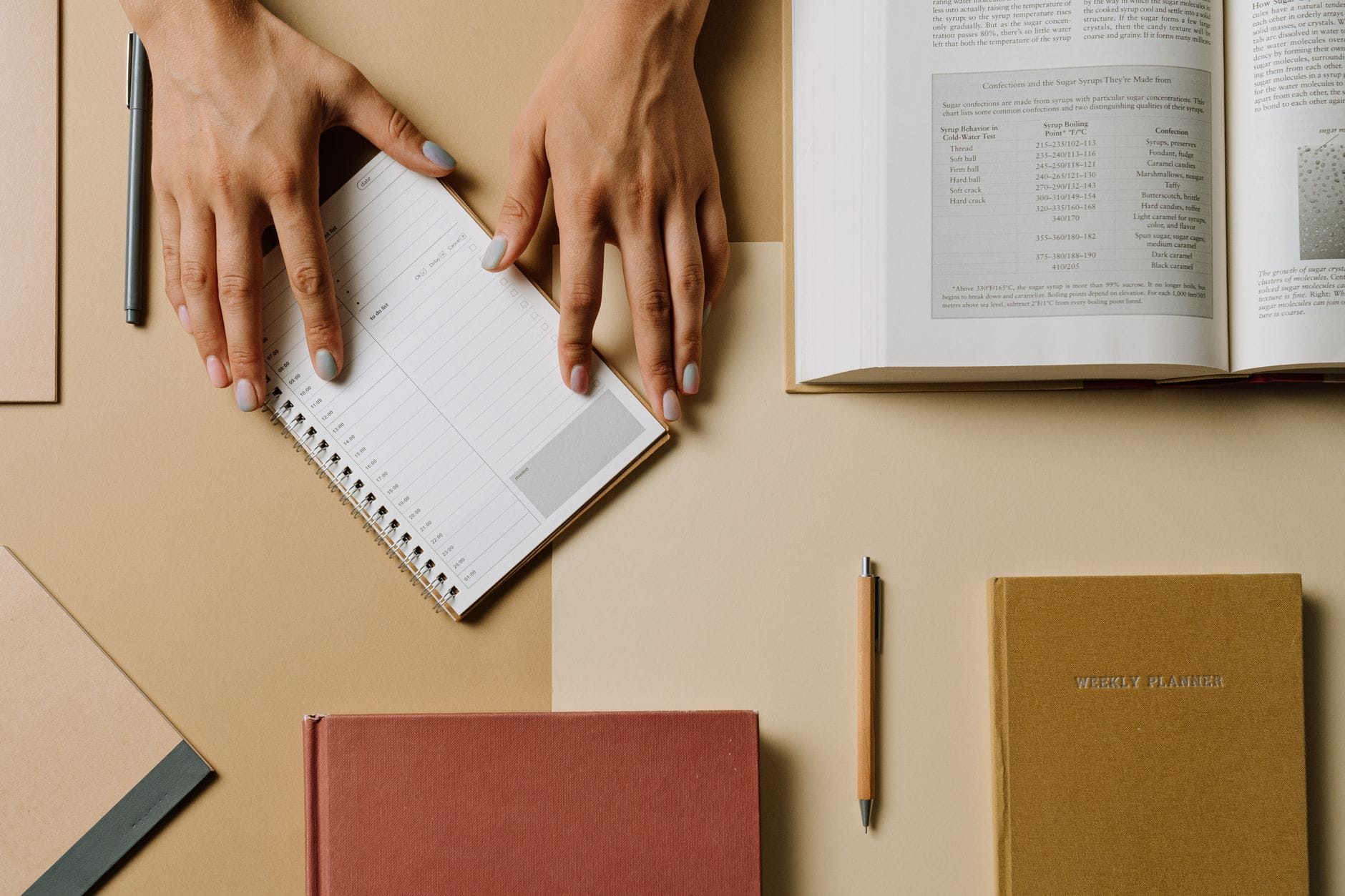 Open planner notebook with a pen beside a water bottle and towel