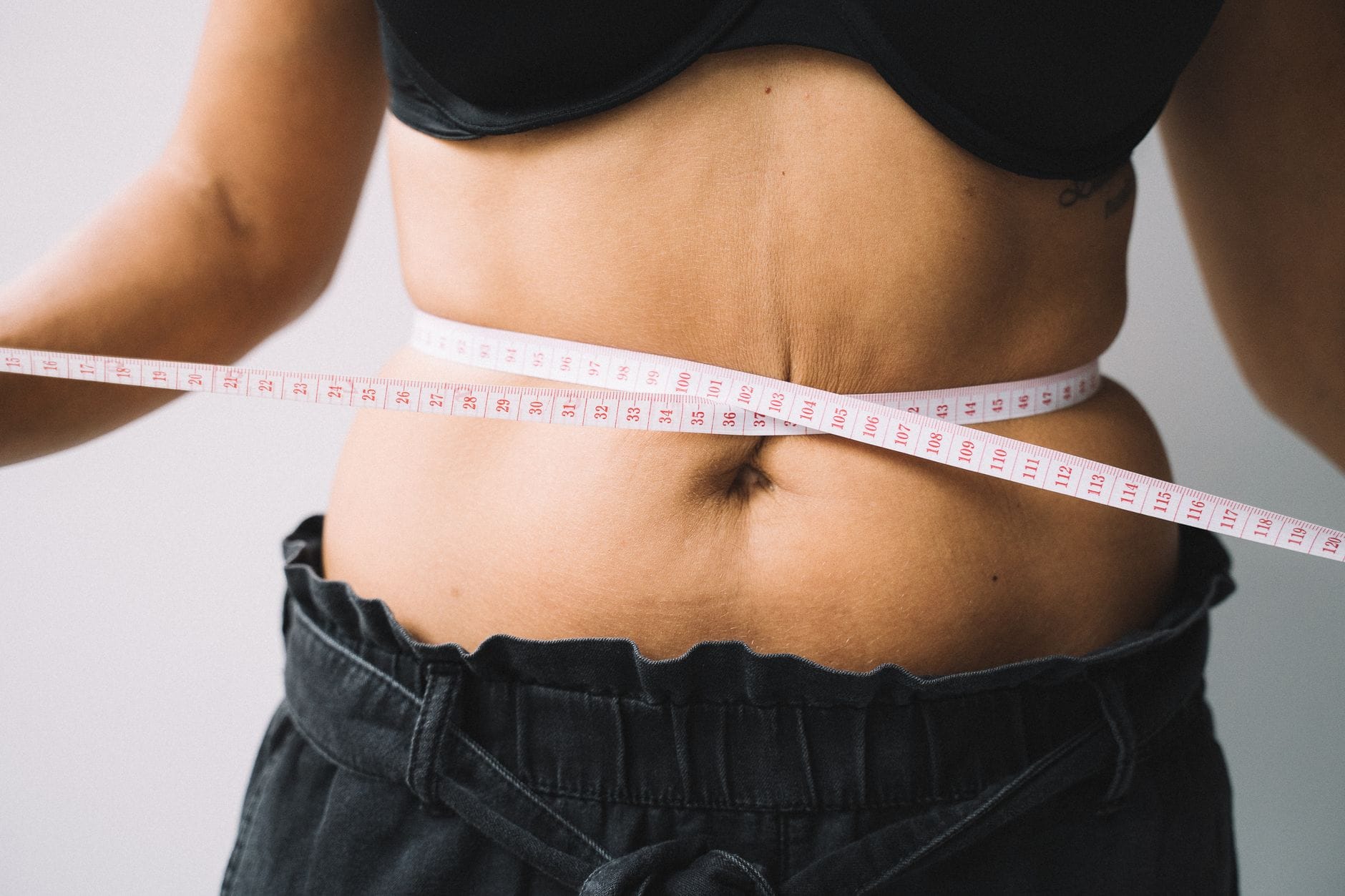 A measuring tape wrapped around a slim person's waist