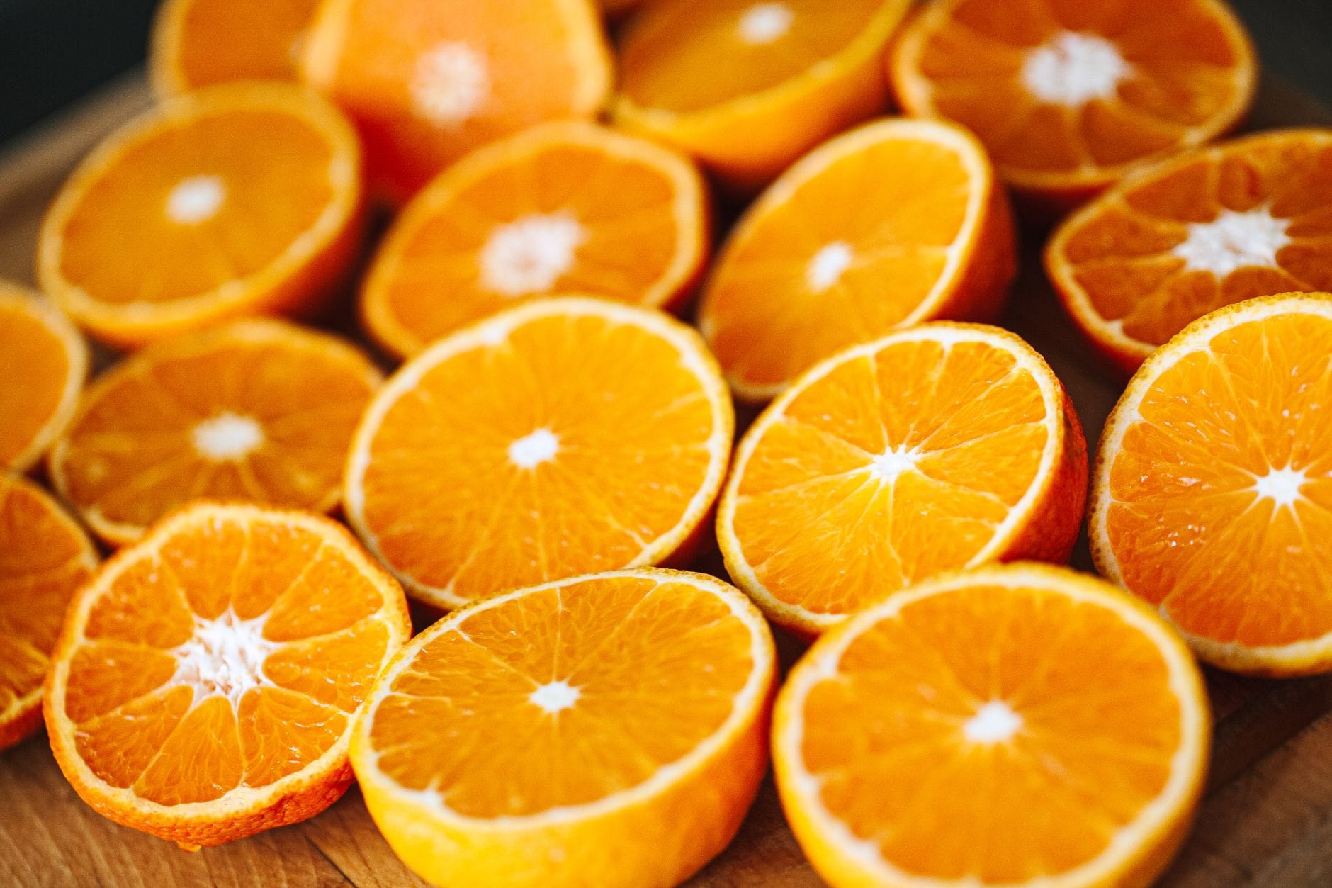 Fresh orange slices and green herbs arranged beside a small dropper bottle