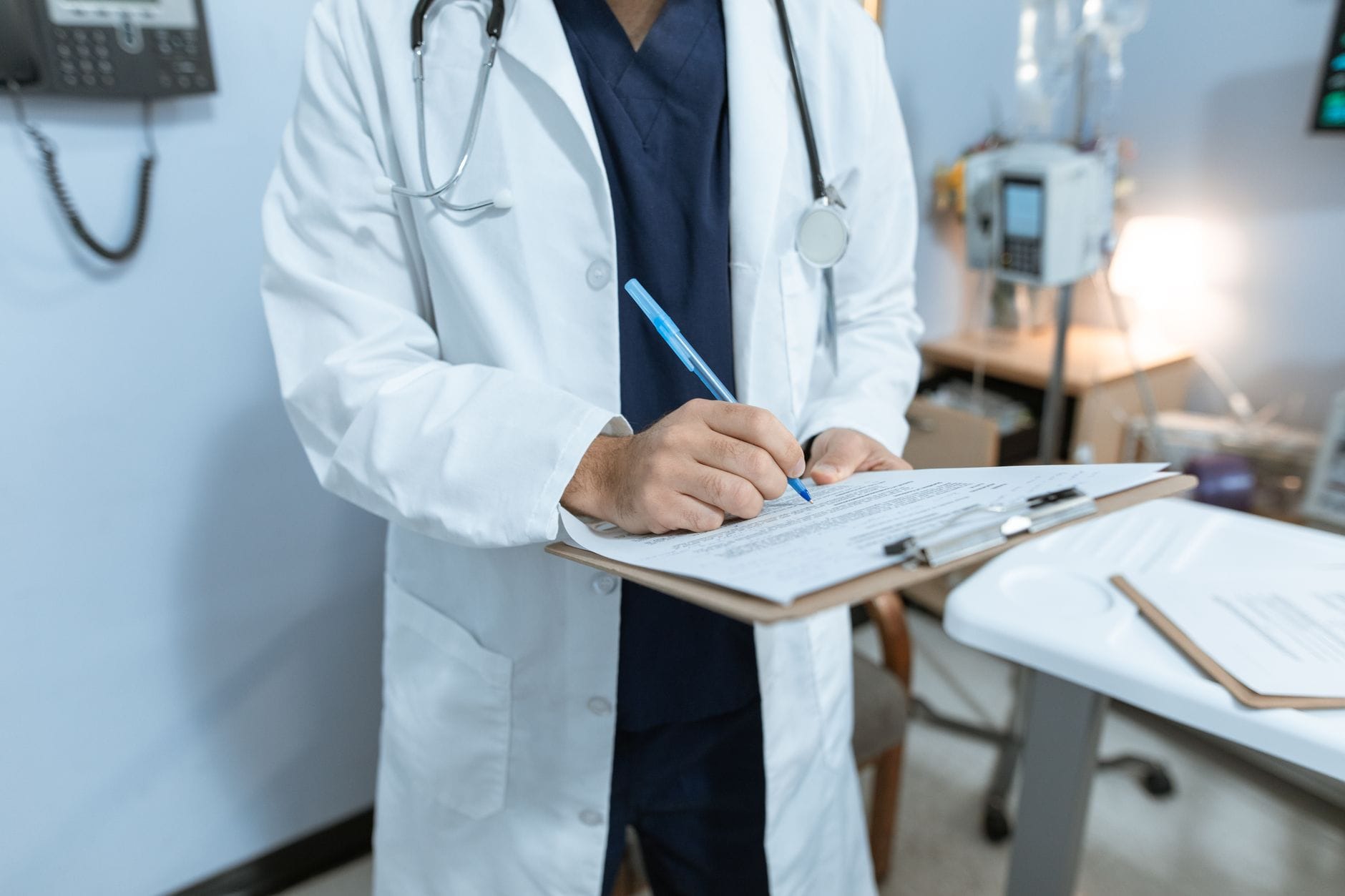 A doctor in a white coat reviewing notes on a clipboard