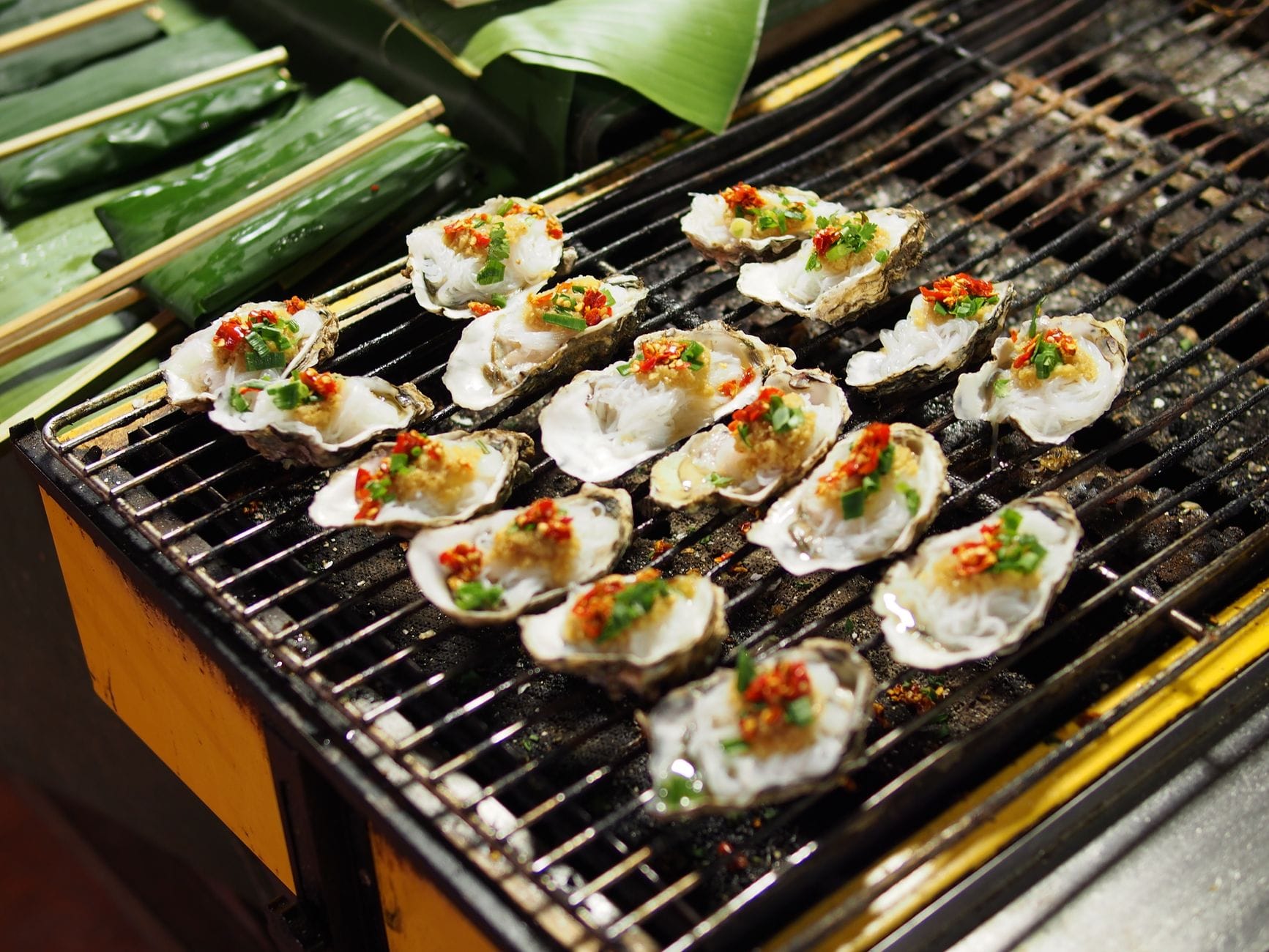 Freshly grilled oysters sizzling in a cast iron skillet