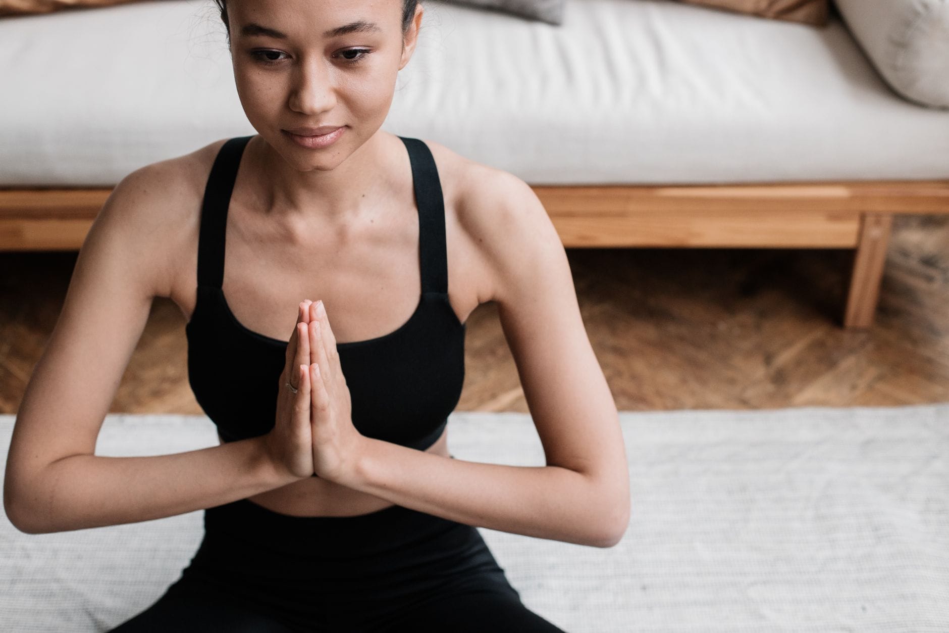 Woman sitting cross-legged on a cushion with her eyes closed