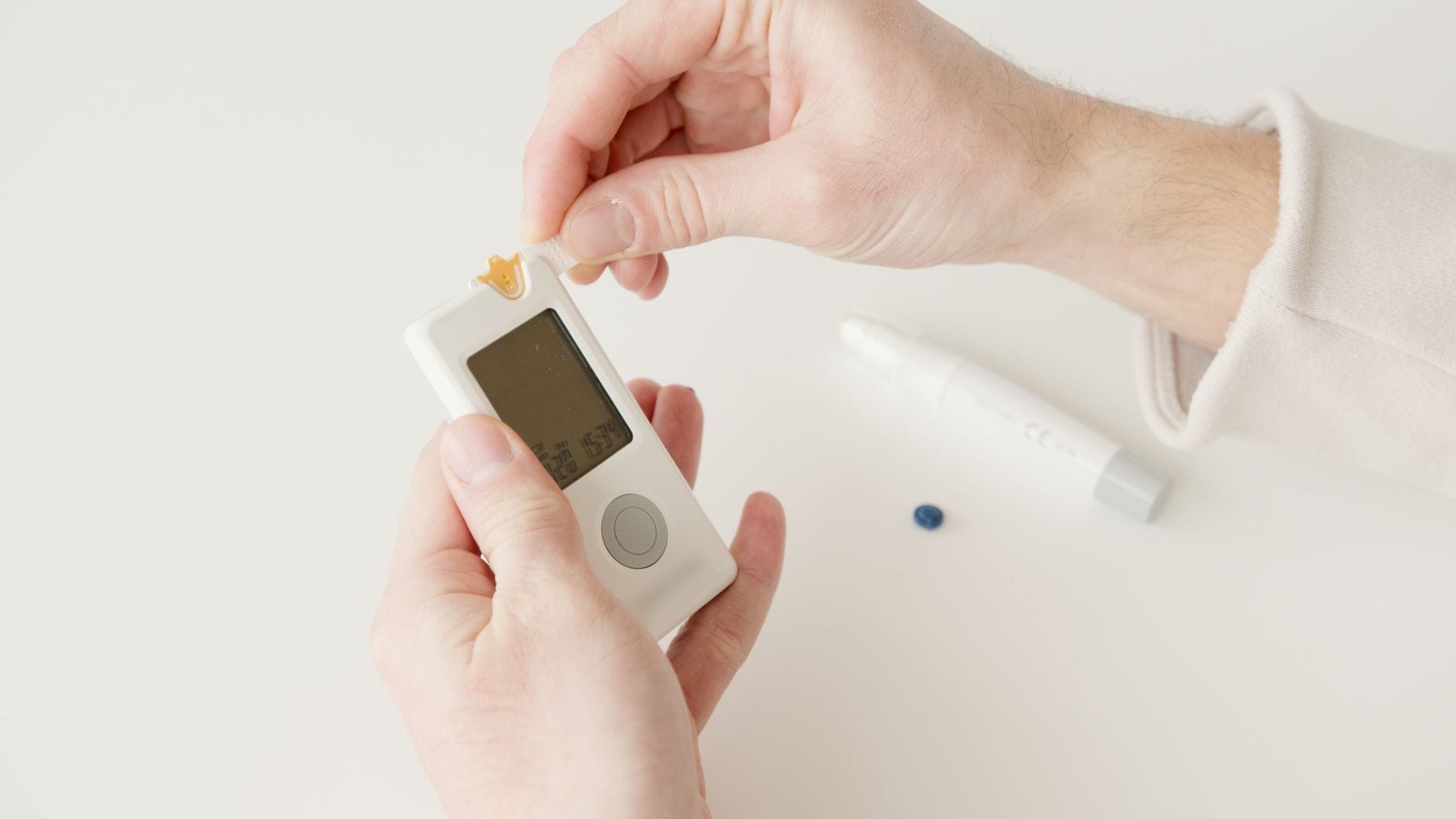 A fingertip glucose meter displaying a blood sugar reading