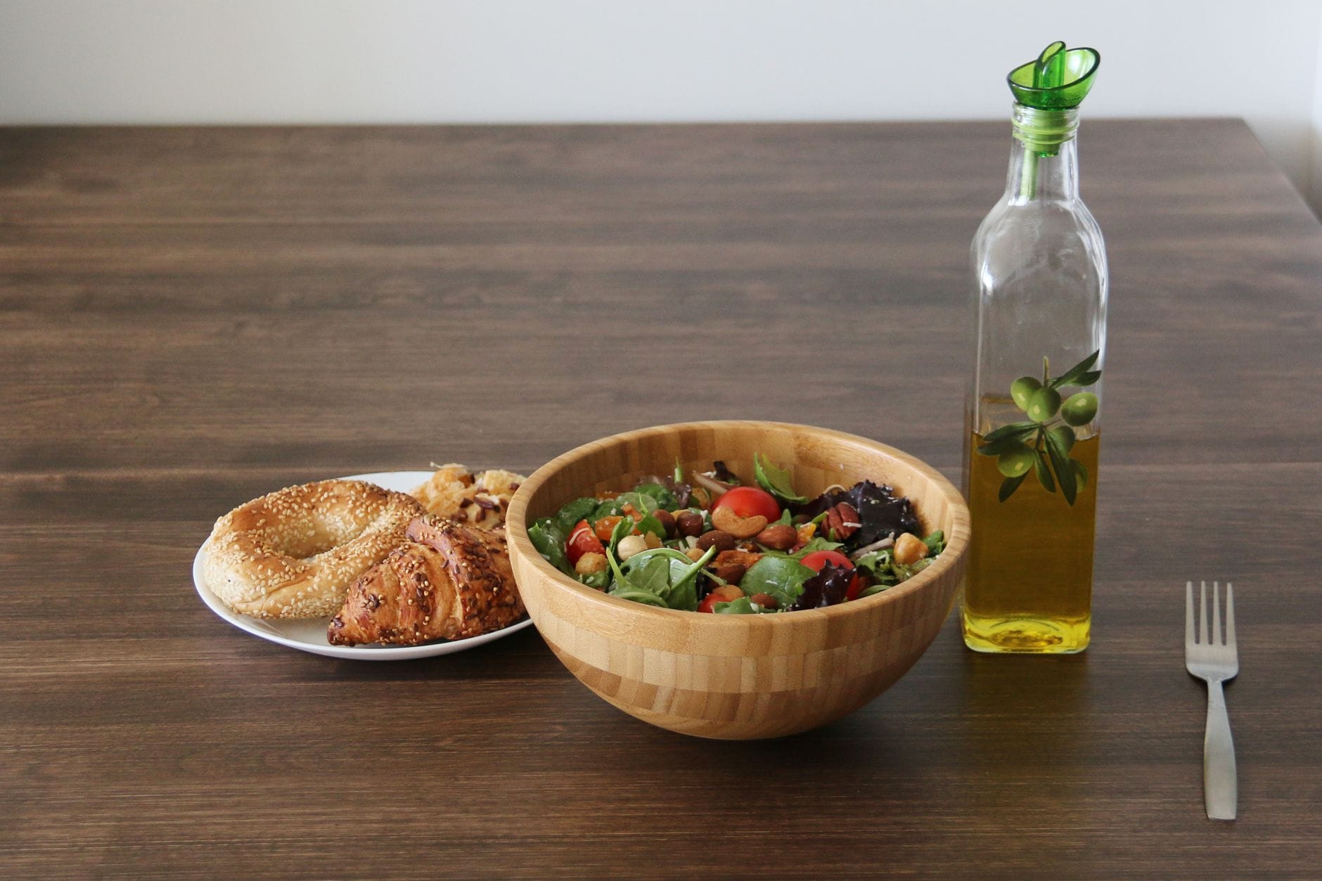 Amber glass bottle of sesame oil next to scattered sesame seeds on a table
