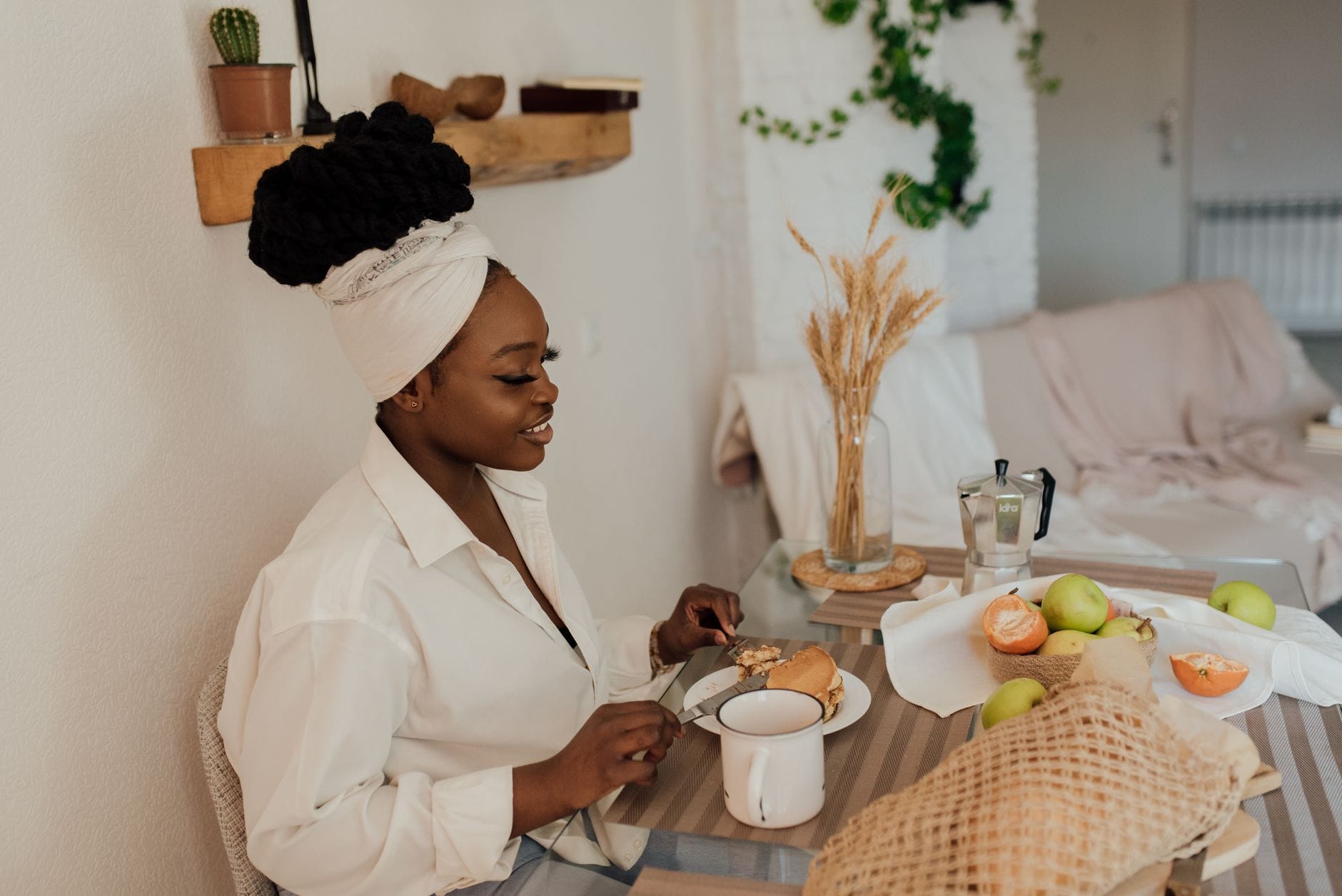 Woman sitting at a kitchen table enjoying a bowl of oatmeal