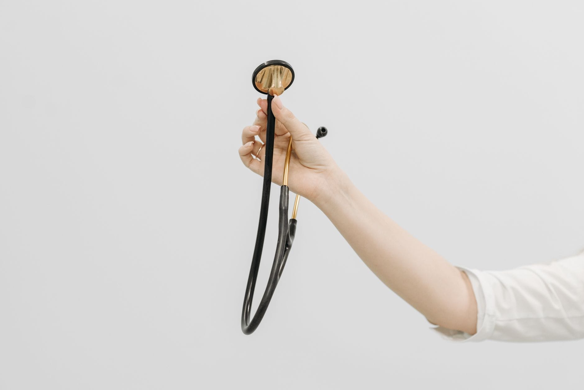 A physician in a white coat greeting a patient in an office