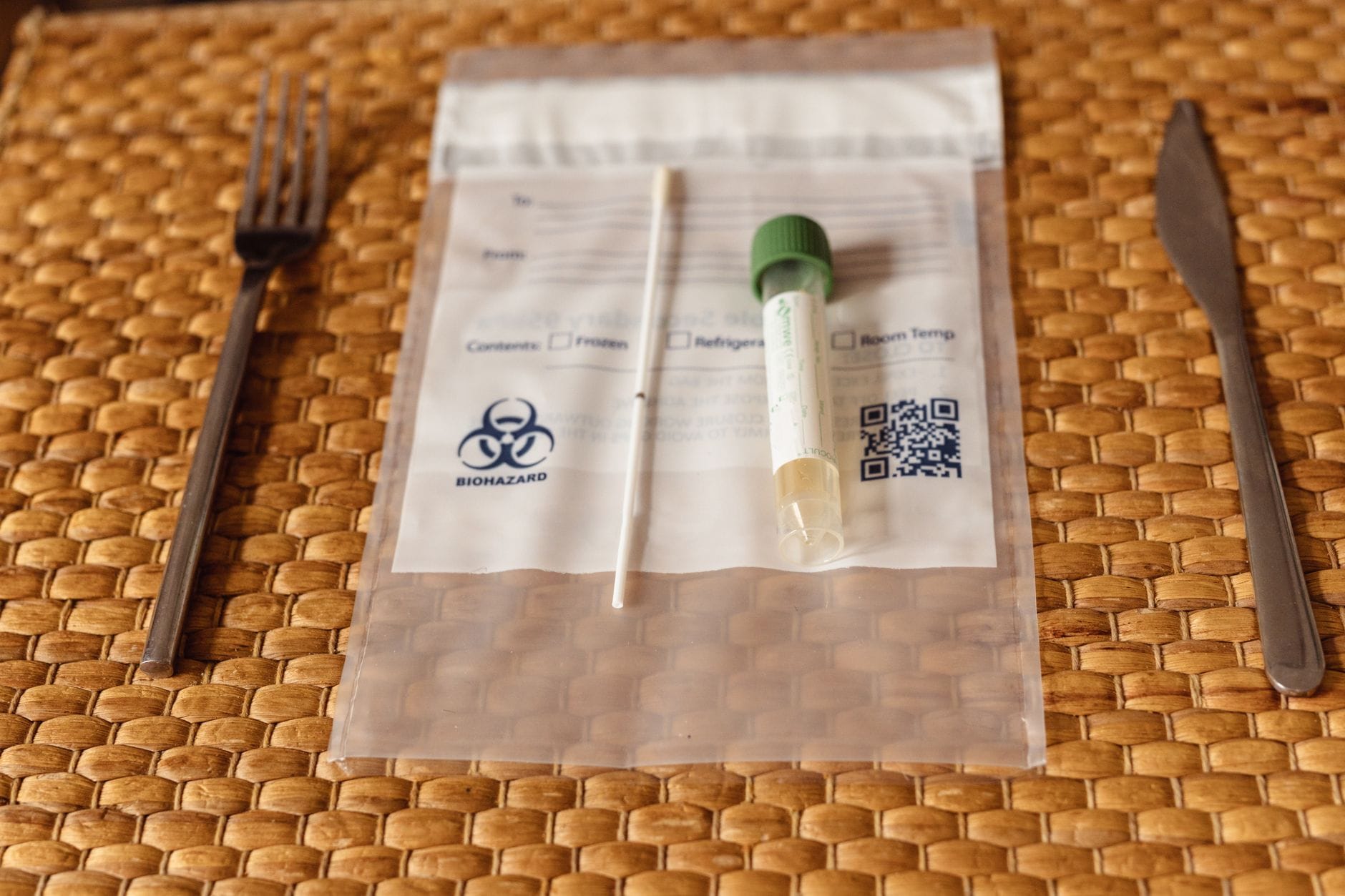 Person holding a cheek swab DNA test kit near a lab tube
