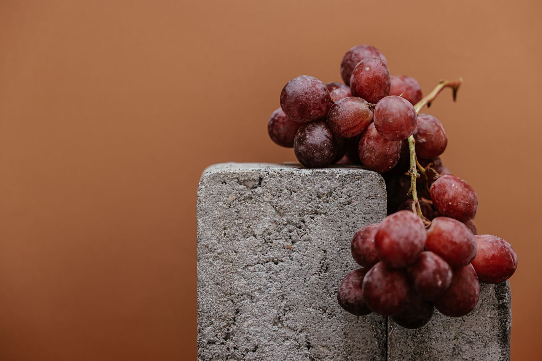 Cluster of deep red grapes resting on a wooden table